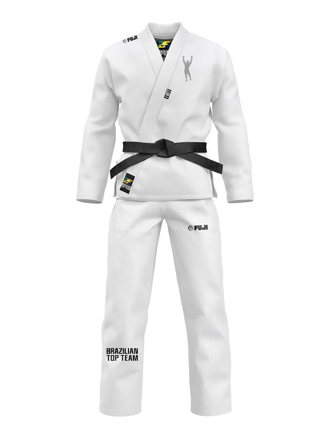 The BTT 25th Anniversary Ultra Lite White Gi features a black belt, Brazilian Top Team logo on the left pant leg, and FUJI branding on the jacket and pants. It is displayed on a plain white background.