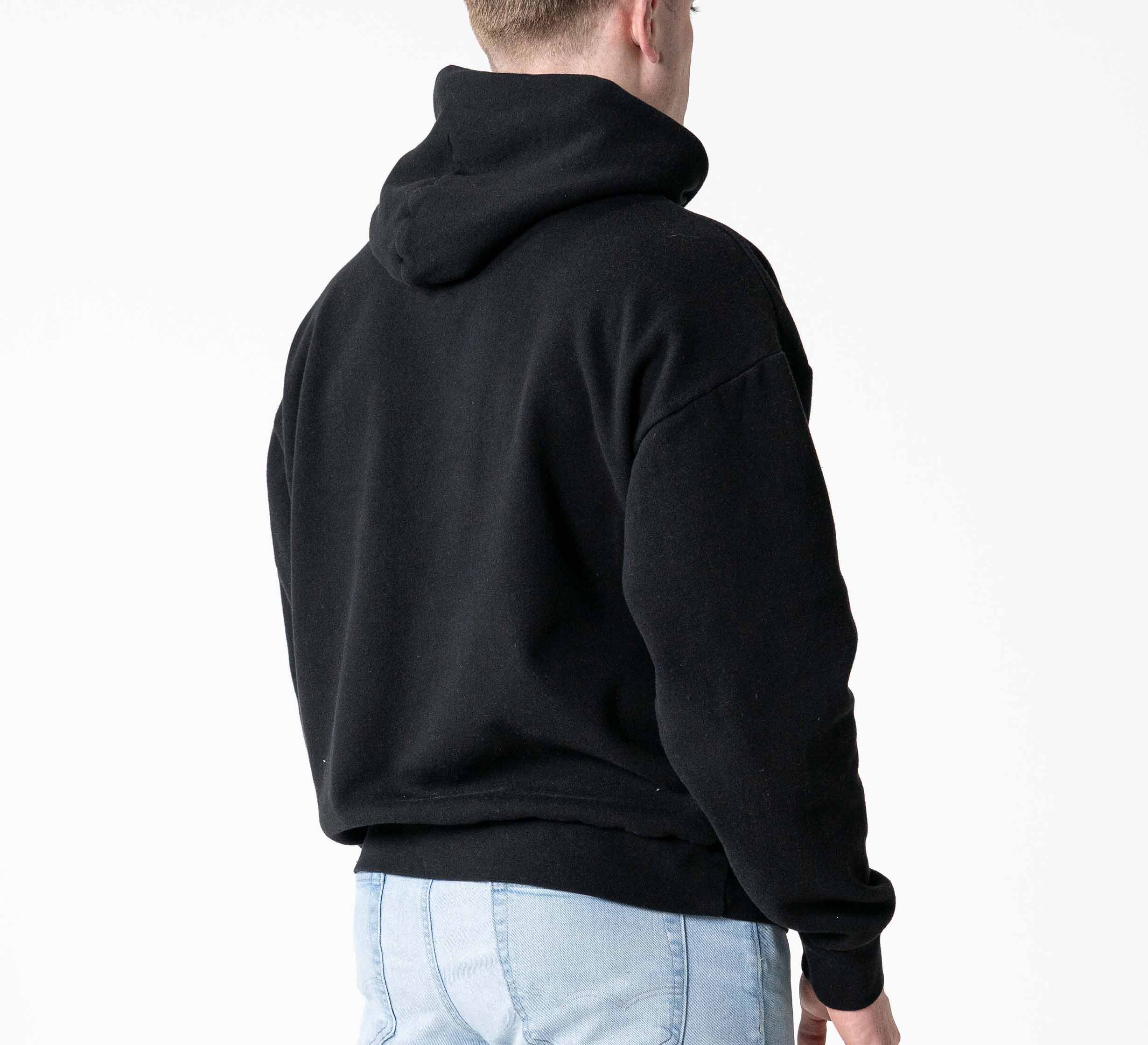 A person wearing the Signature Hoodie Black and light blue jeans stands with their back to the camera against a plain white background.
