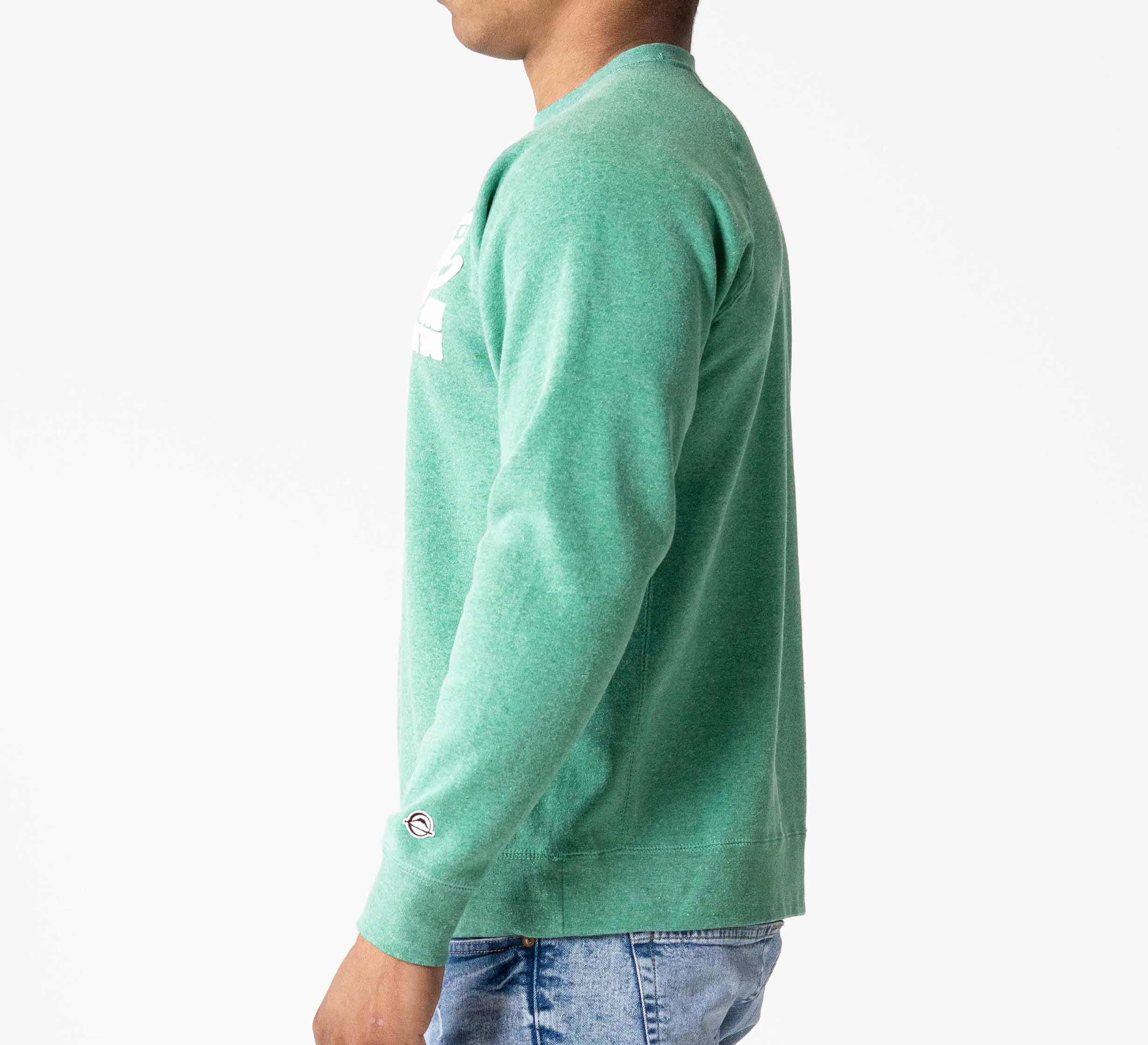 A person is shown from the side, facing left, wearing the Signature Crewneck Green and blue jeans against a plain white background.