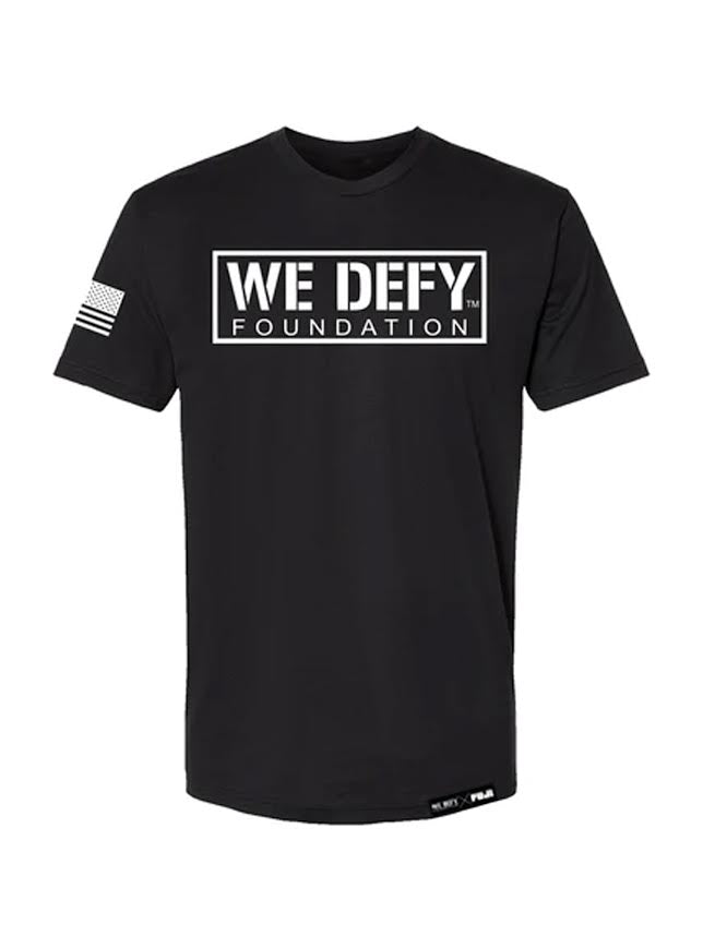 The We Defy Base T-Shirt Black features "WE DEFY FOUNDATION" in bold white letters inside a rectangle on the chest and a small American flag graphic on the right sleeve.