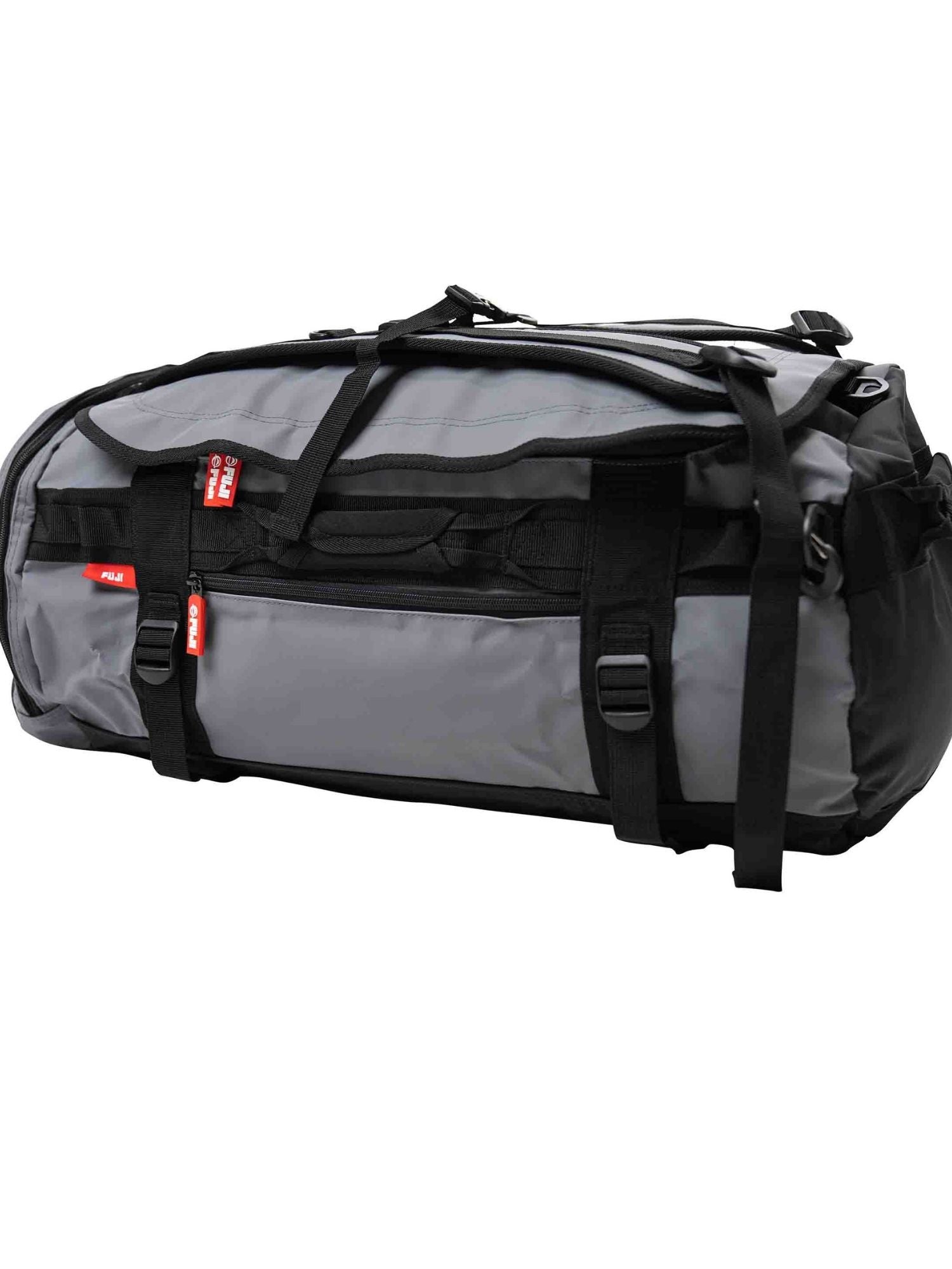 The Comp Convertible Backpack Duffle Grey is a large gray and black bag with multiple straps, handles, and red tags, shown lying on its side against a plain white background.