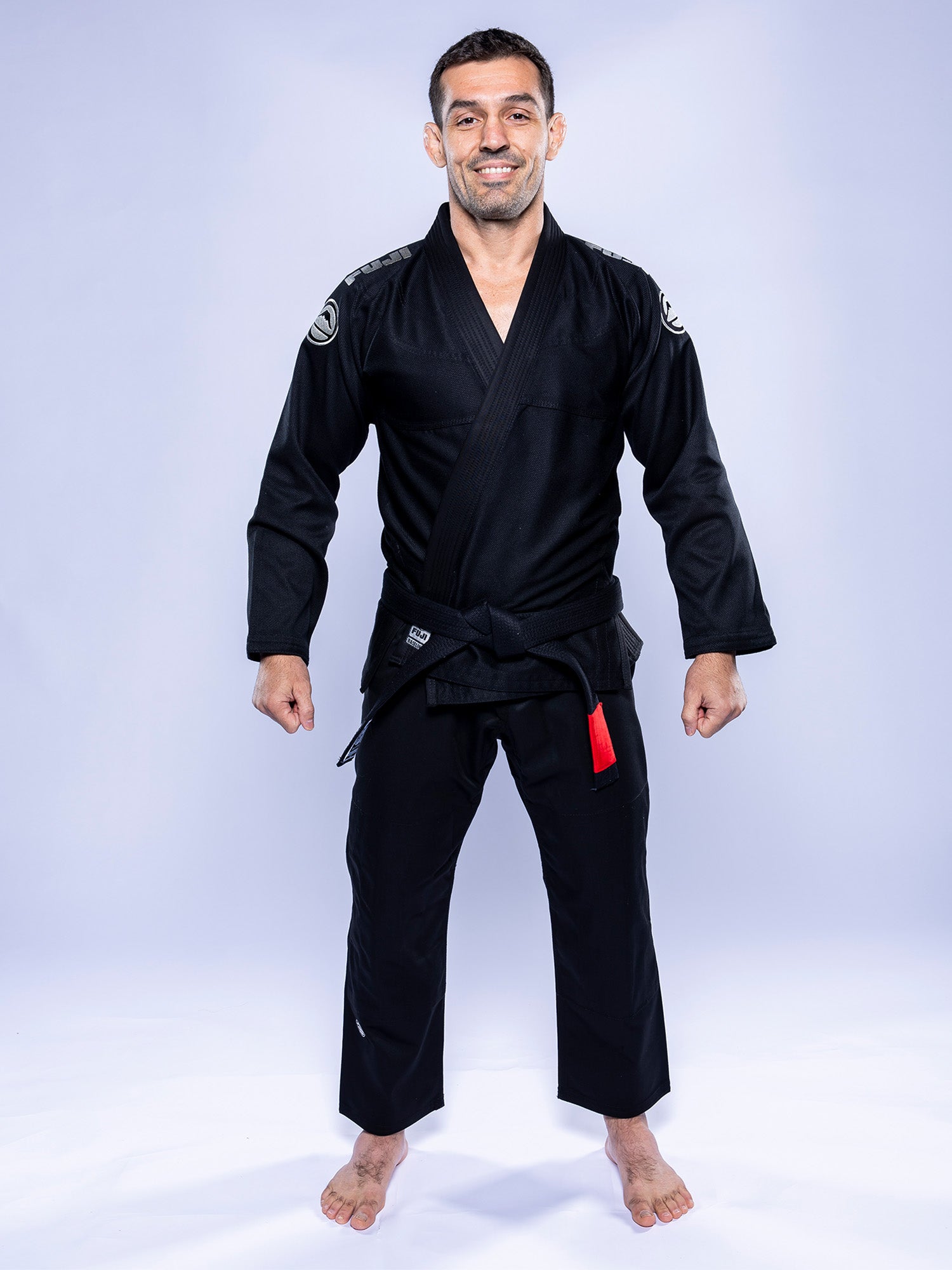 A man wearing the Baseline 2.0 BJJ Gi in black and grey.