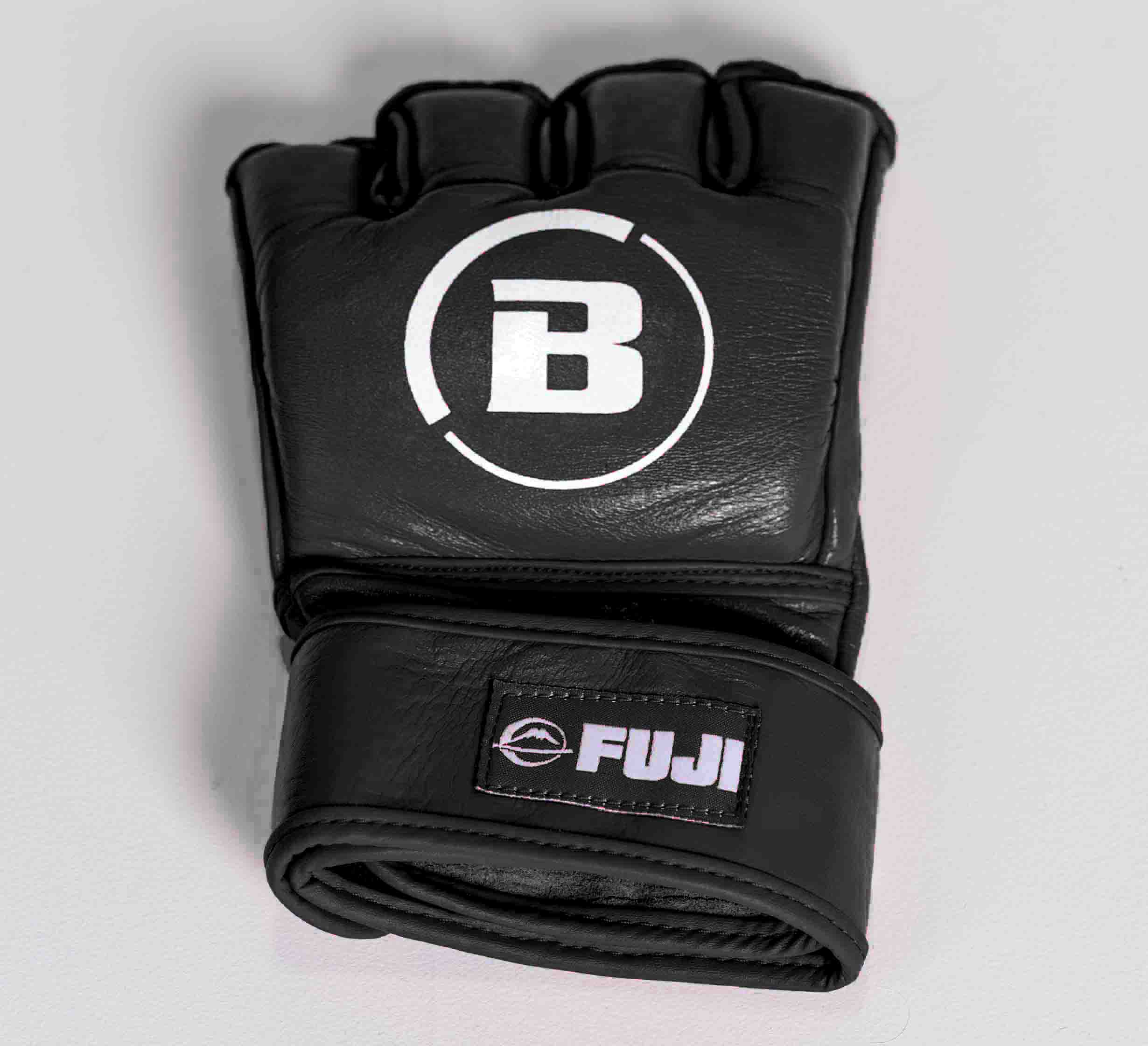 The Bellator MMA Gloves Black feature a white B logo on top and a FUJI patch on the wrist strap, displayed on a light surface.