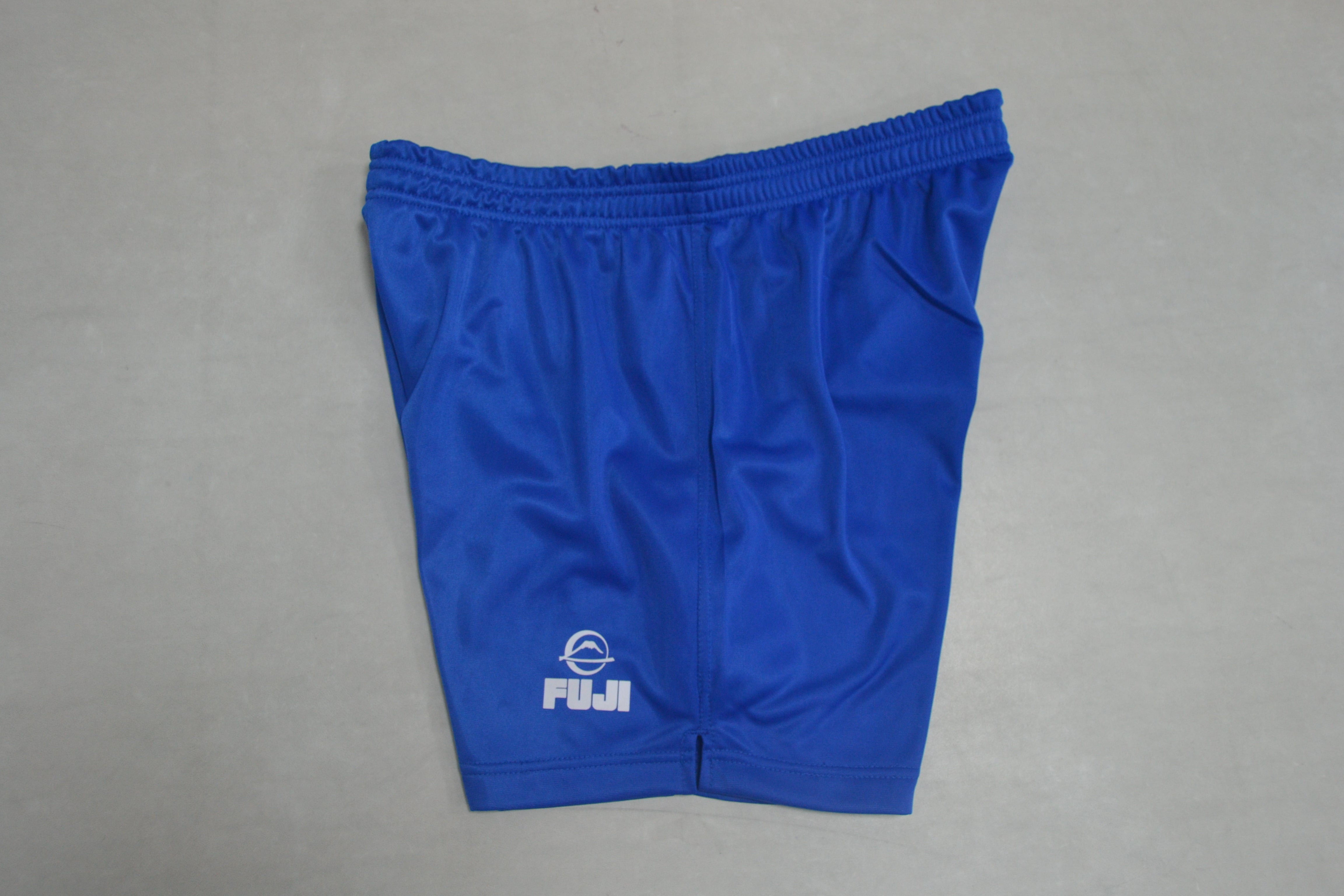 FIAS Sambo Shorts Blue featuring an elastic waistband and white Fuji logo on the lower left leg, displayed flat on a gray surface.