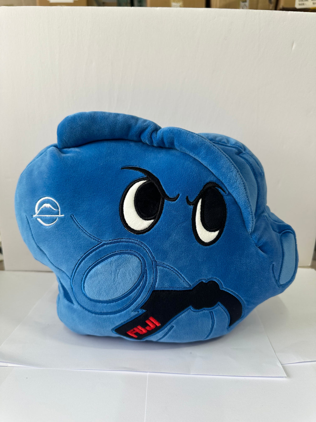 The Pochi Piro Pillow Blue is a plush toy shaped like an anatomical heart with cartoon eyes, a determined expression, and “FUJI” on a black detail. It sits on a white surface against a white background.