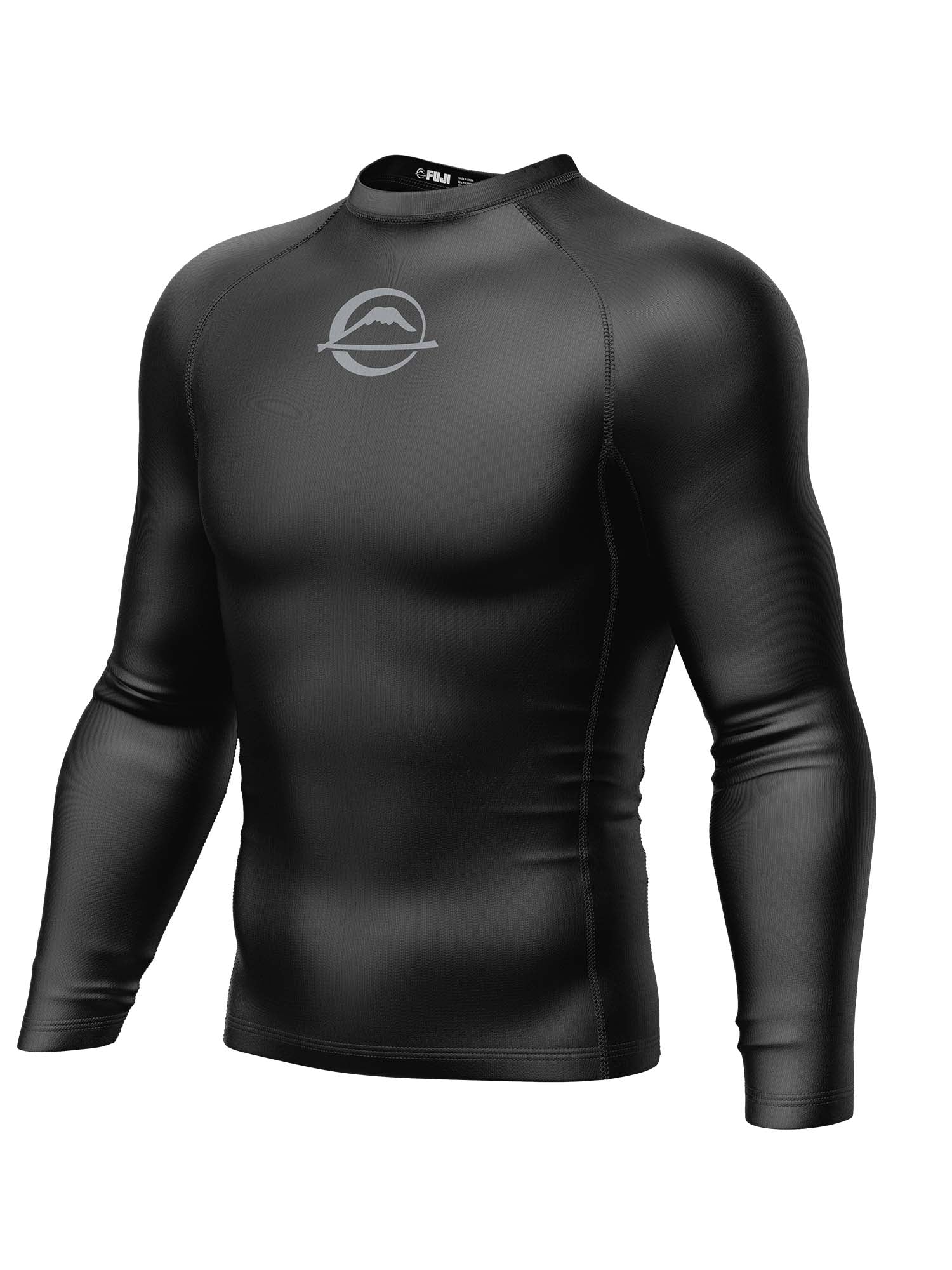 The Baseline Ranked Long Sleeve Rashguard Black is a fitted black athletic compression shirt with long sleeves and a small circular white logo on the upper chest, featuring no visible buttons or zippers.
