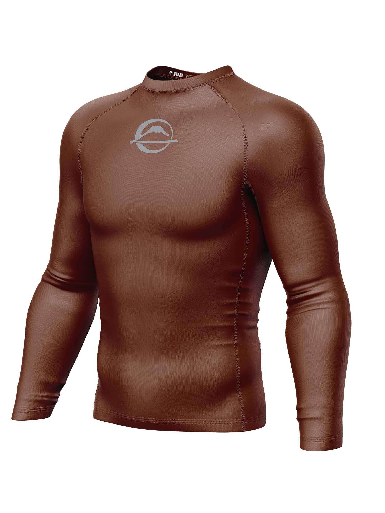 The Baseline Ranked Long Sleeve Rashguard Brown is a form-fitting, long-sleeve athletic shirt in brown with a small white stylized wave and circle logo on the upper chest, shown on a plain white background.