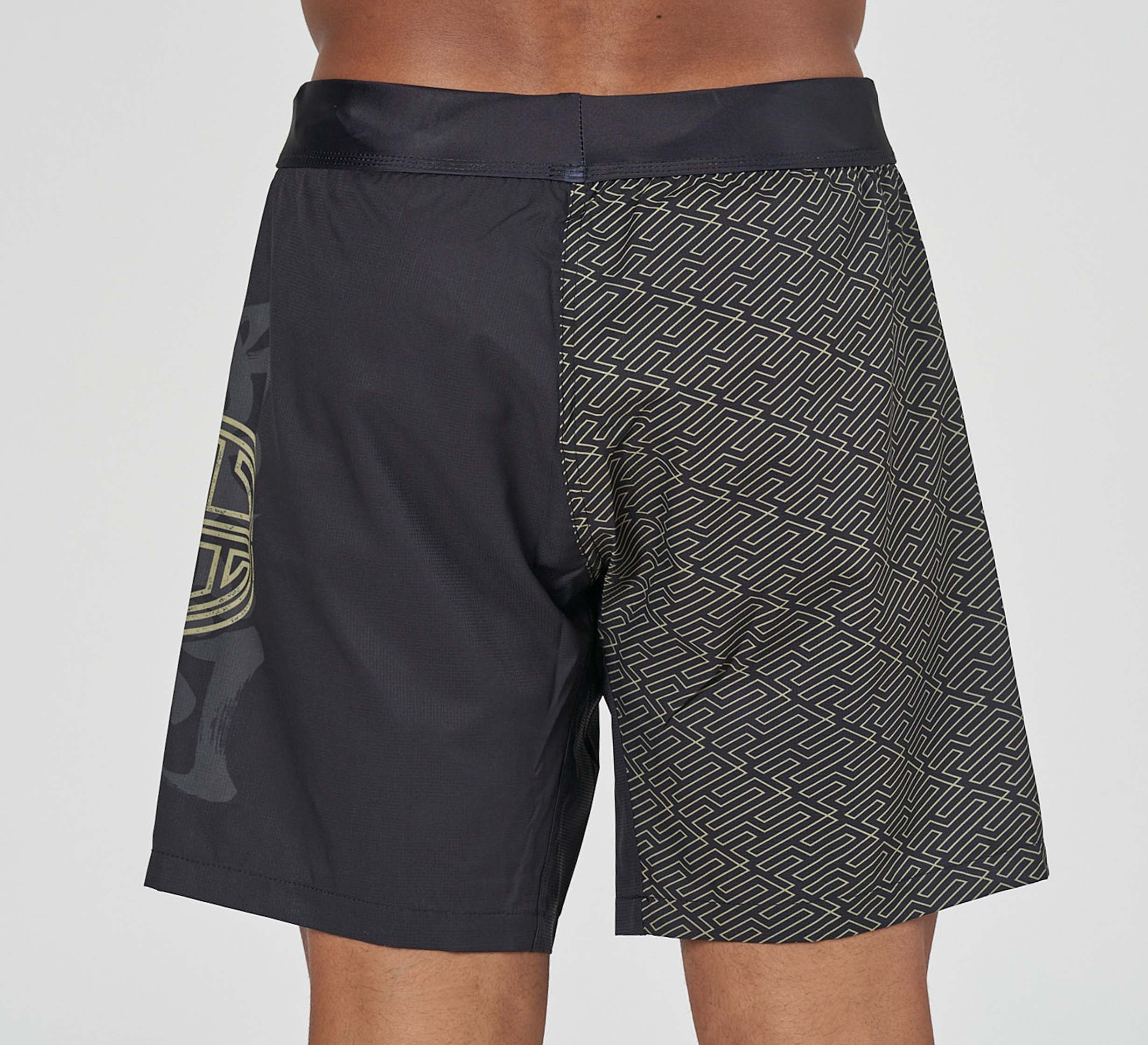 A person wearing Bushido Flex Lite Shorts, featuring a geometric pattern on one side and a solid black panel with a subtle circular design on the other, viewed from the back.