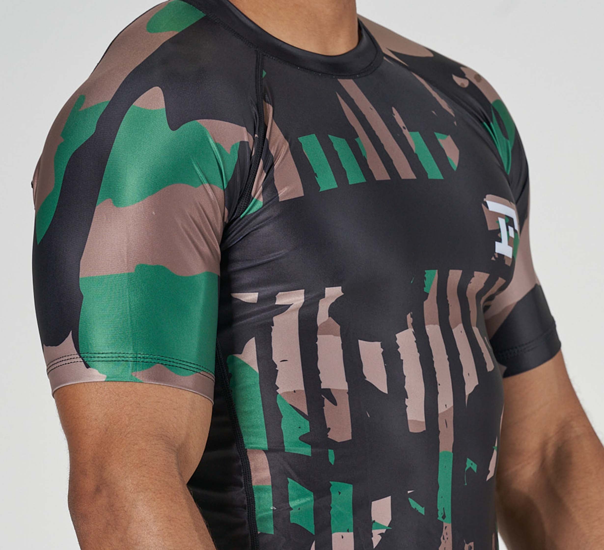 A man wearing the Camo Flex Lite Rashguard.