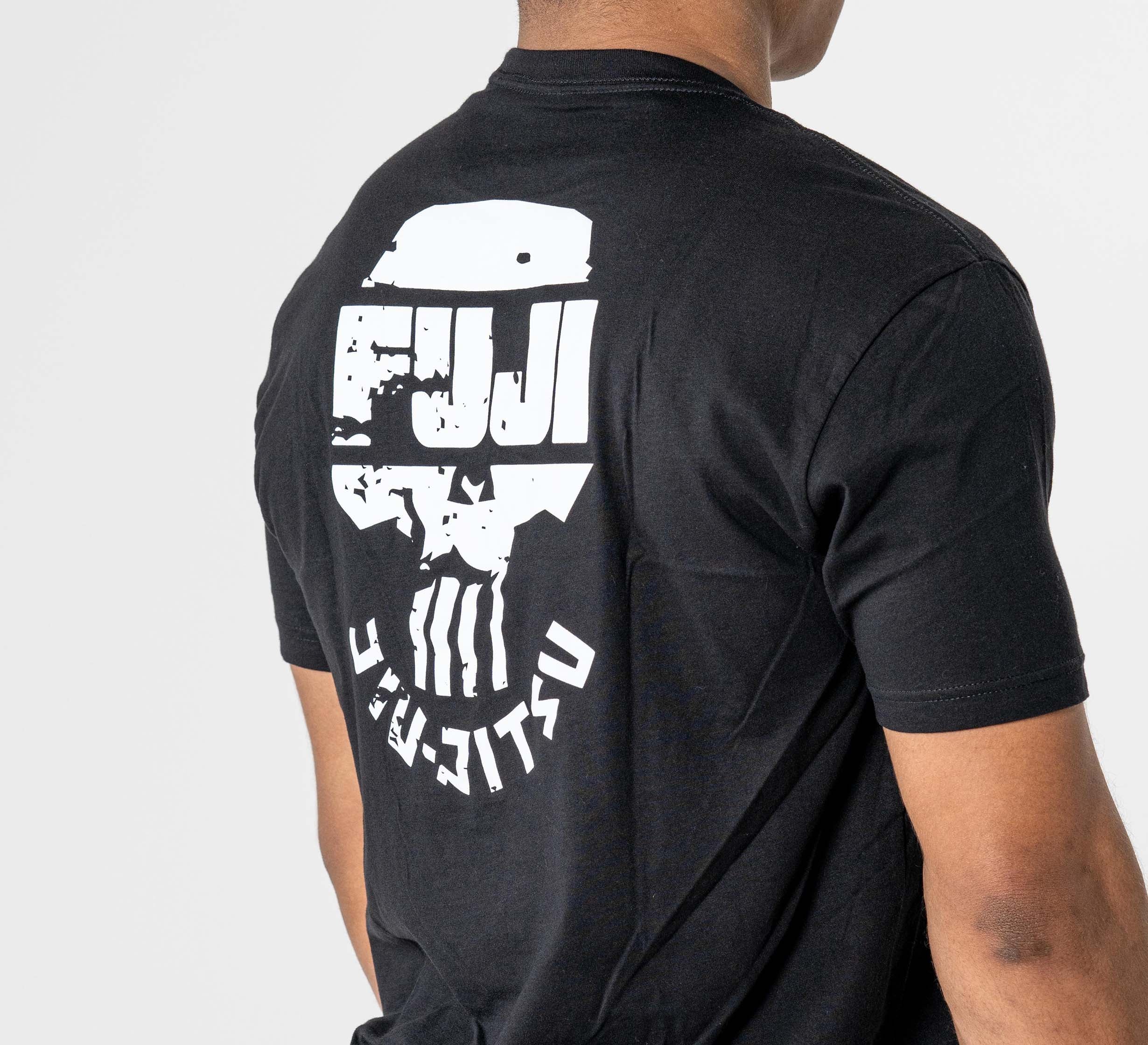 A person wearing the Punishment T-Shirt Black, featuring a large white Fuji Jiu-Jitsu skull logo and Japanese text on the back, is facing away from the camera.