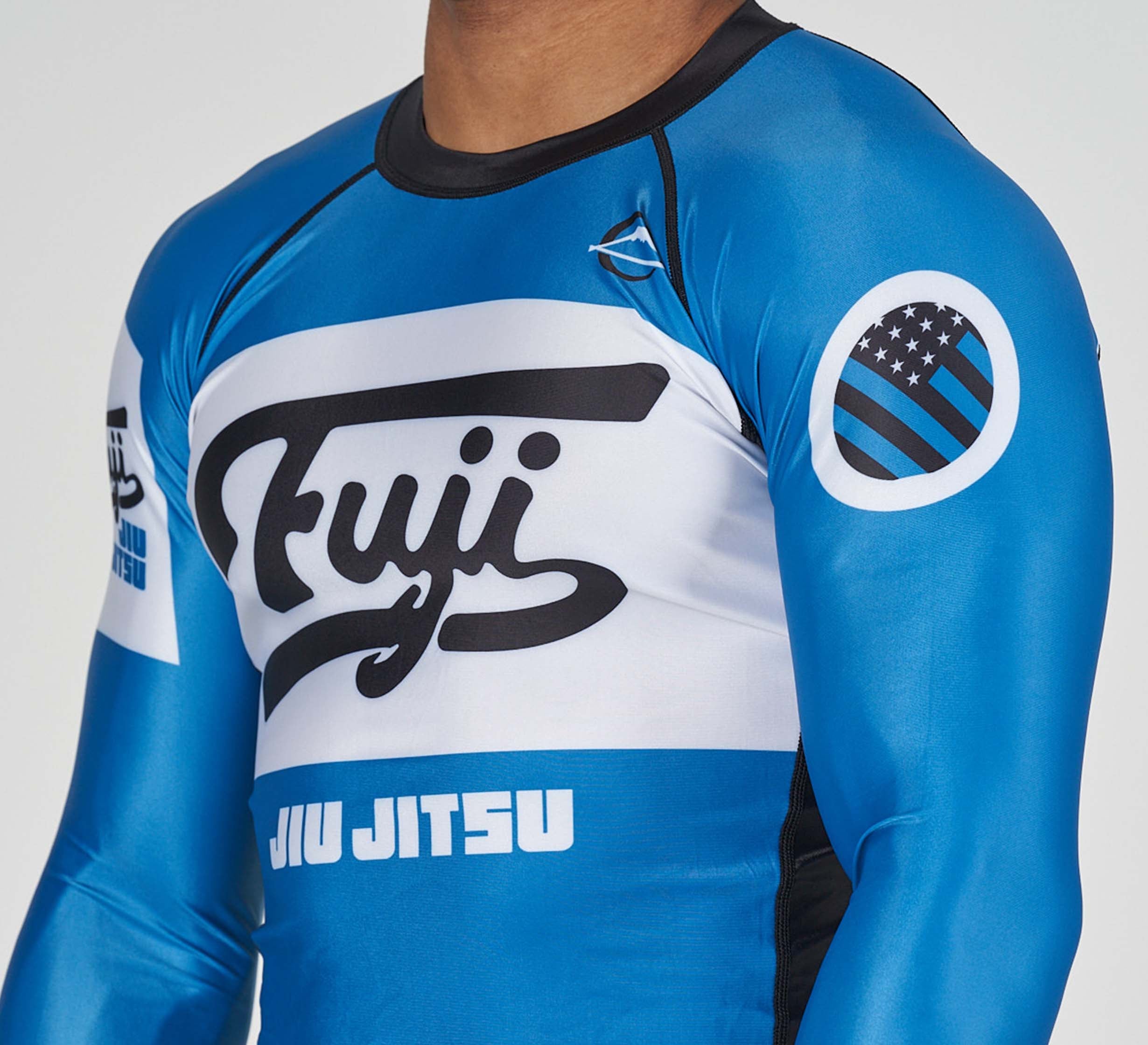 A man wearing the Jiu Jitsu Script Flex Lite Long Sleeve Rashguard in blue.