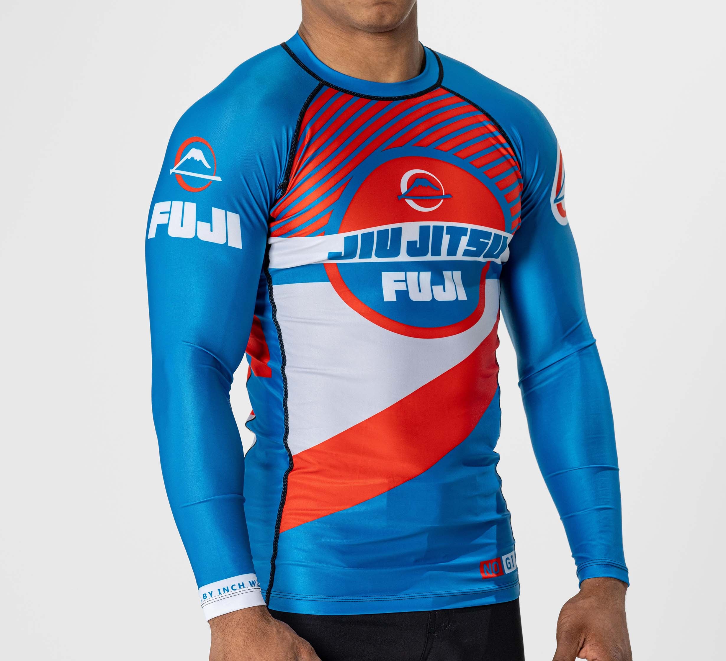 A person wearing a Pacer Flex Lite Long Sleeve Rashguard Blue/Red with bold graphics and logos stands against a plain white background.