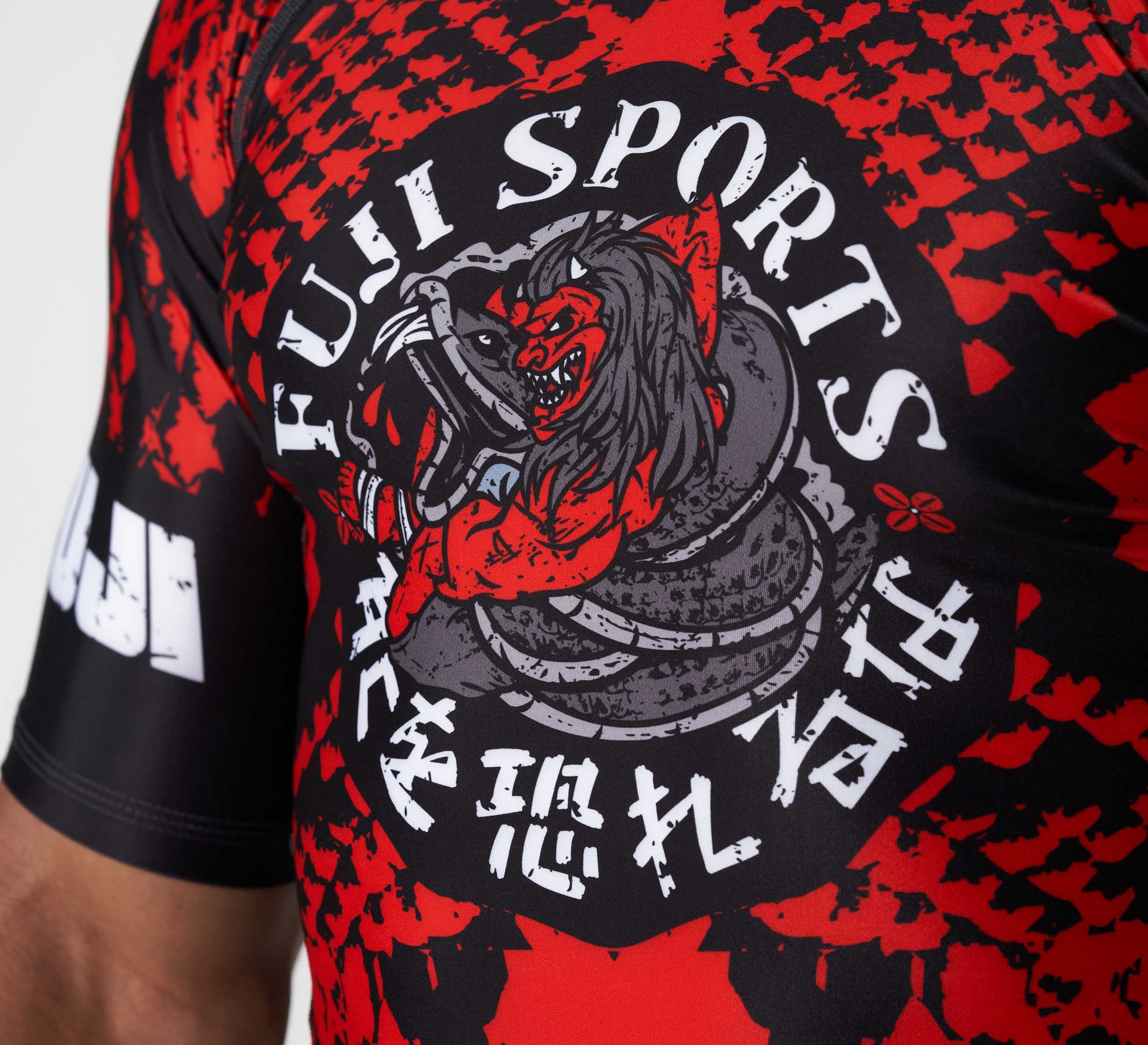 Close-up of the Oni vs. Anaconda Short Sleeve Rashguard Red, featuring a dynamic oni wrestling an anaconda, with “FUJI SPORTS” and Japanese characters surrounding the graphic.