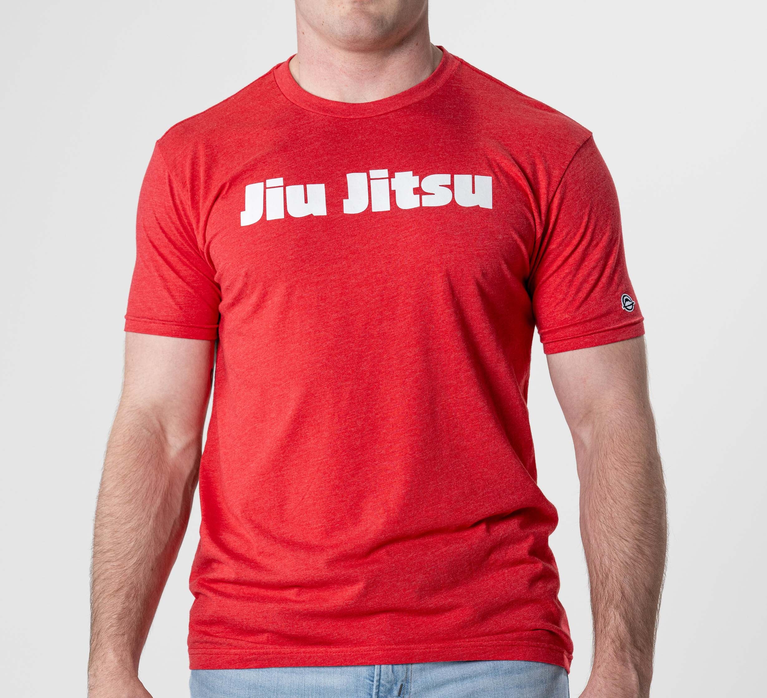 A person models the Jiu Jitsu Player T-Shirt Red, featuring bold white “Jiu Jitsu” lettering across the chest, set against a plain light gray background.