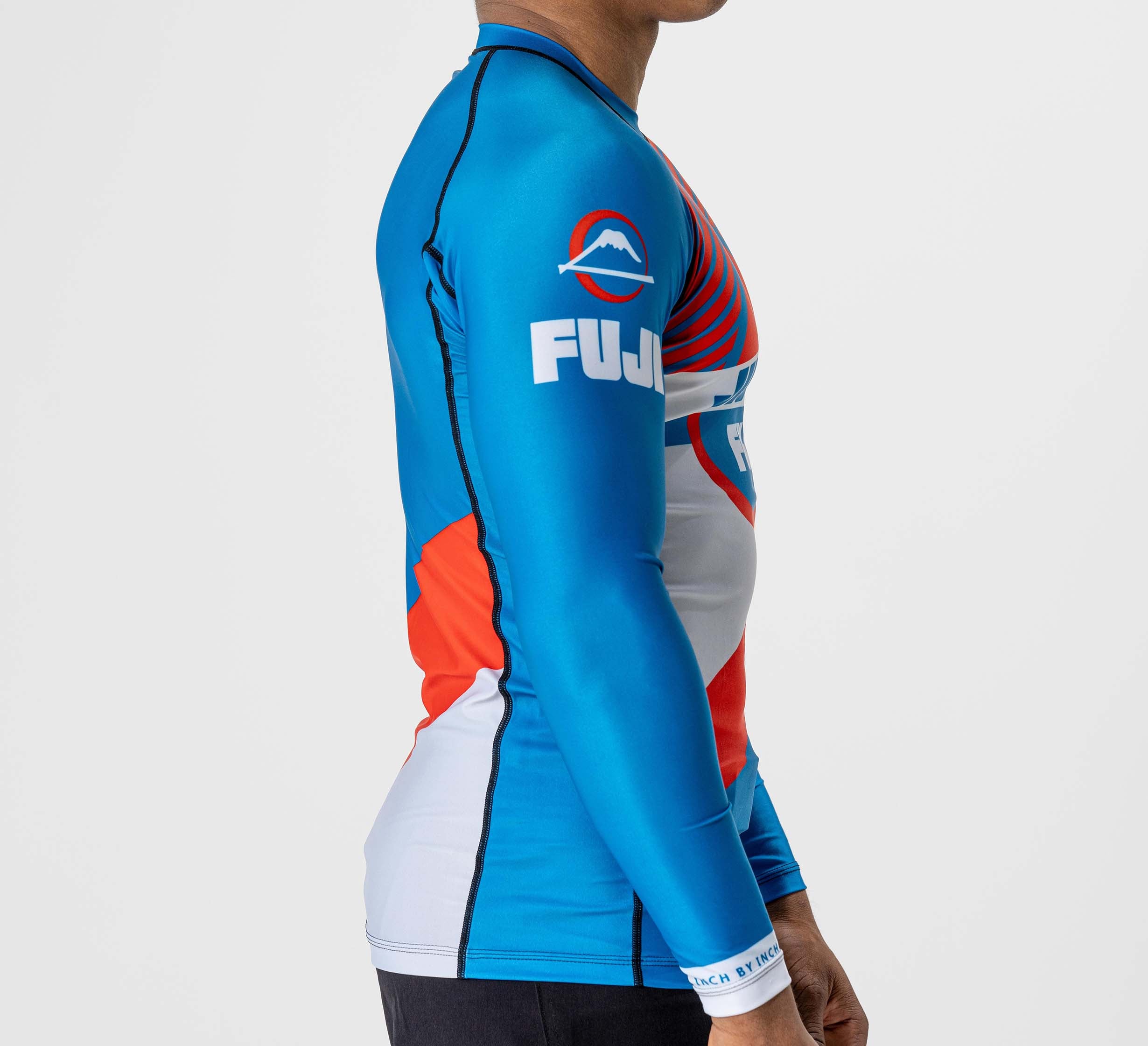 A person wearing the Pacer Flex Lite Long Sleeve Rashguard in blue and red, shown from the side against a plain white background.