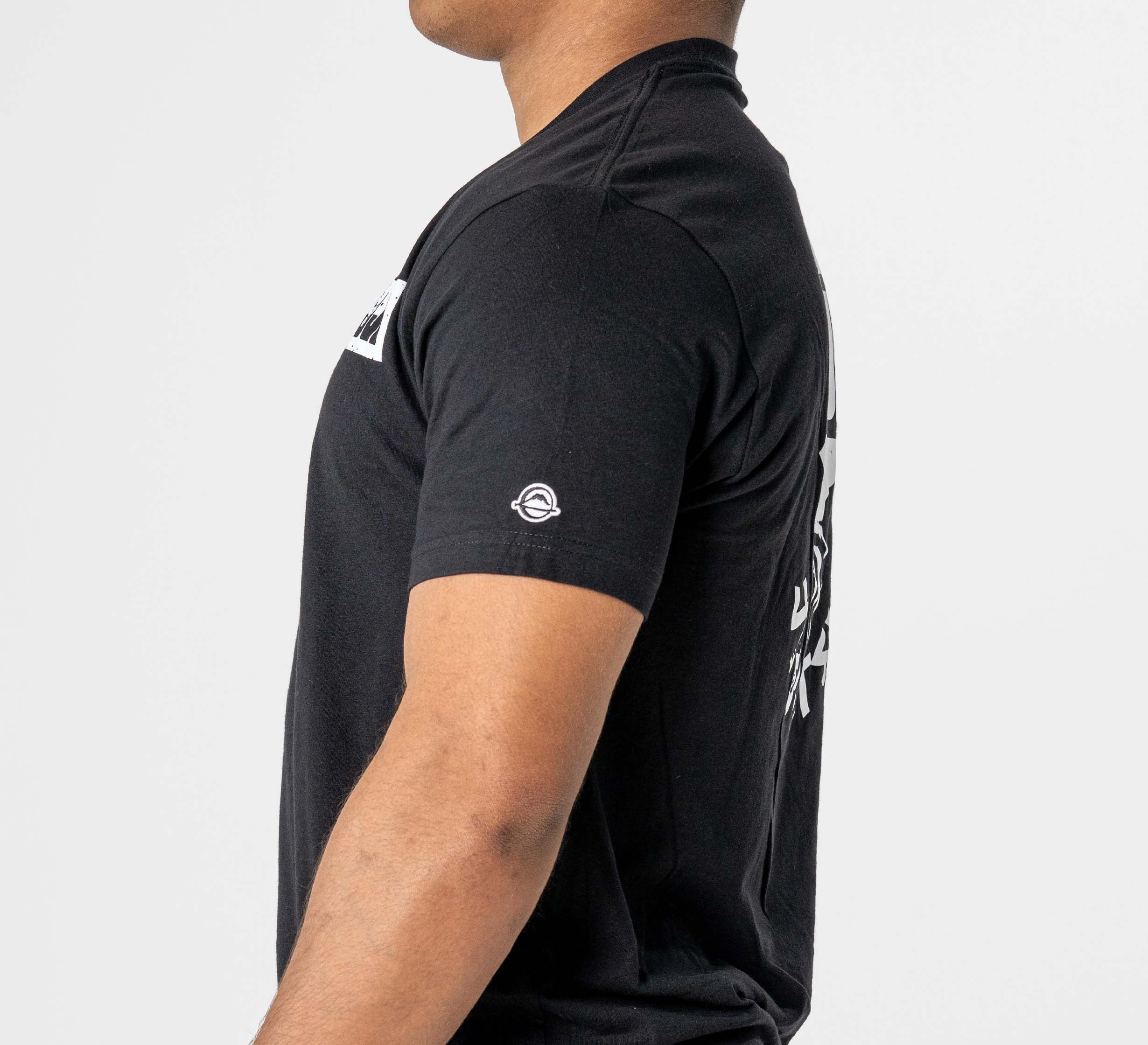 A person wearing the Punishment T-Shirt Black, featuring a small circular white logo on the left sleeve, is shown from the side against a plain white background.