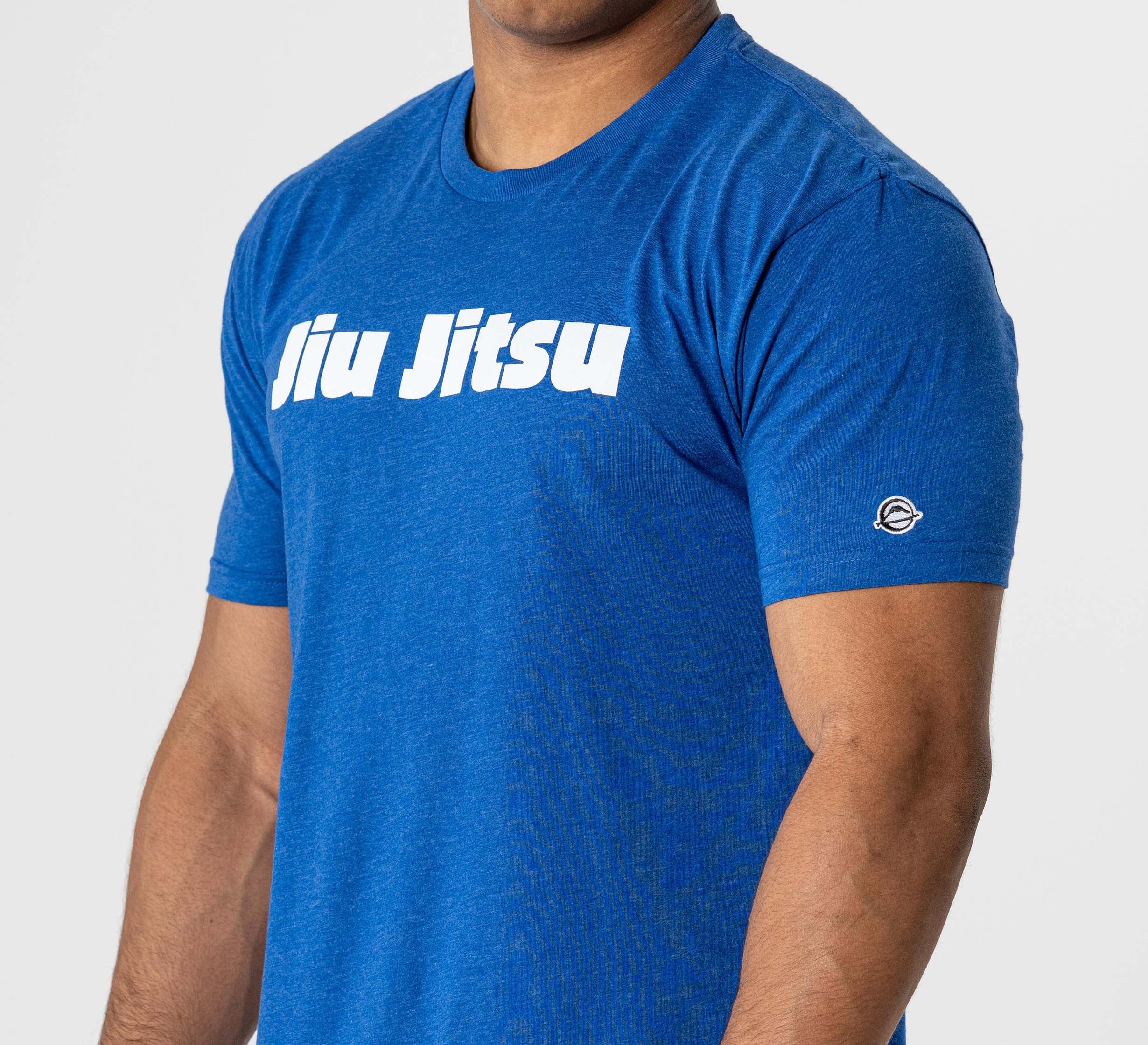 Someone is wearing the Jiu Jitsu Player T-Shirt Blue, featuring "Jiu Jitsu" in bold white letters across the chest and a small circular logo on the left sleeve.