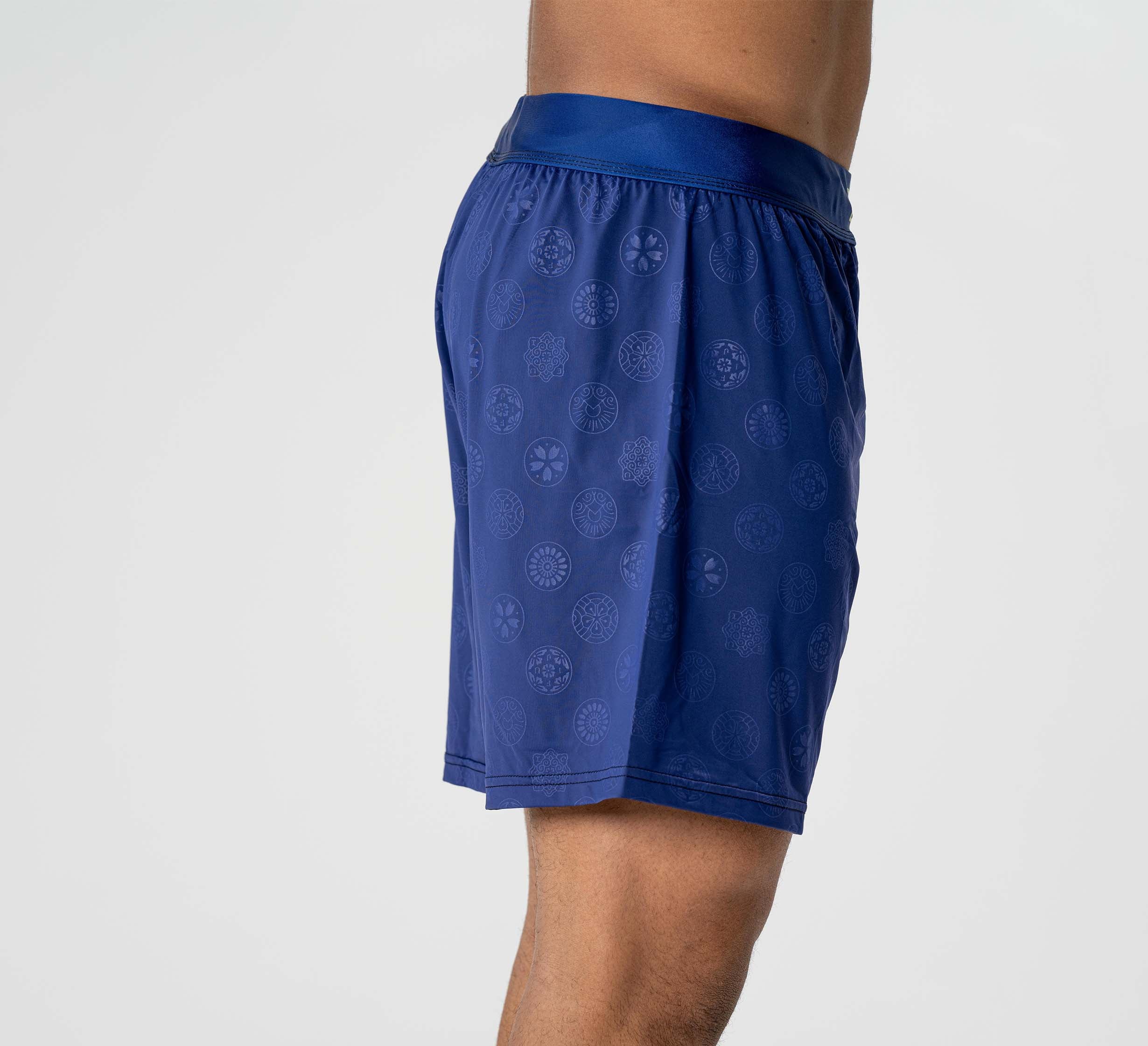 A person models the Shogun Heat Gear Shorts Navy, standing sideways to display the left profile of their lower torso and legs against a plain white background.