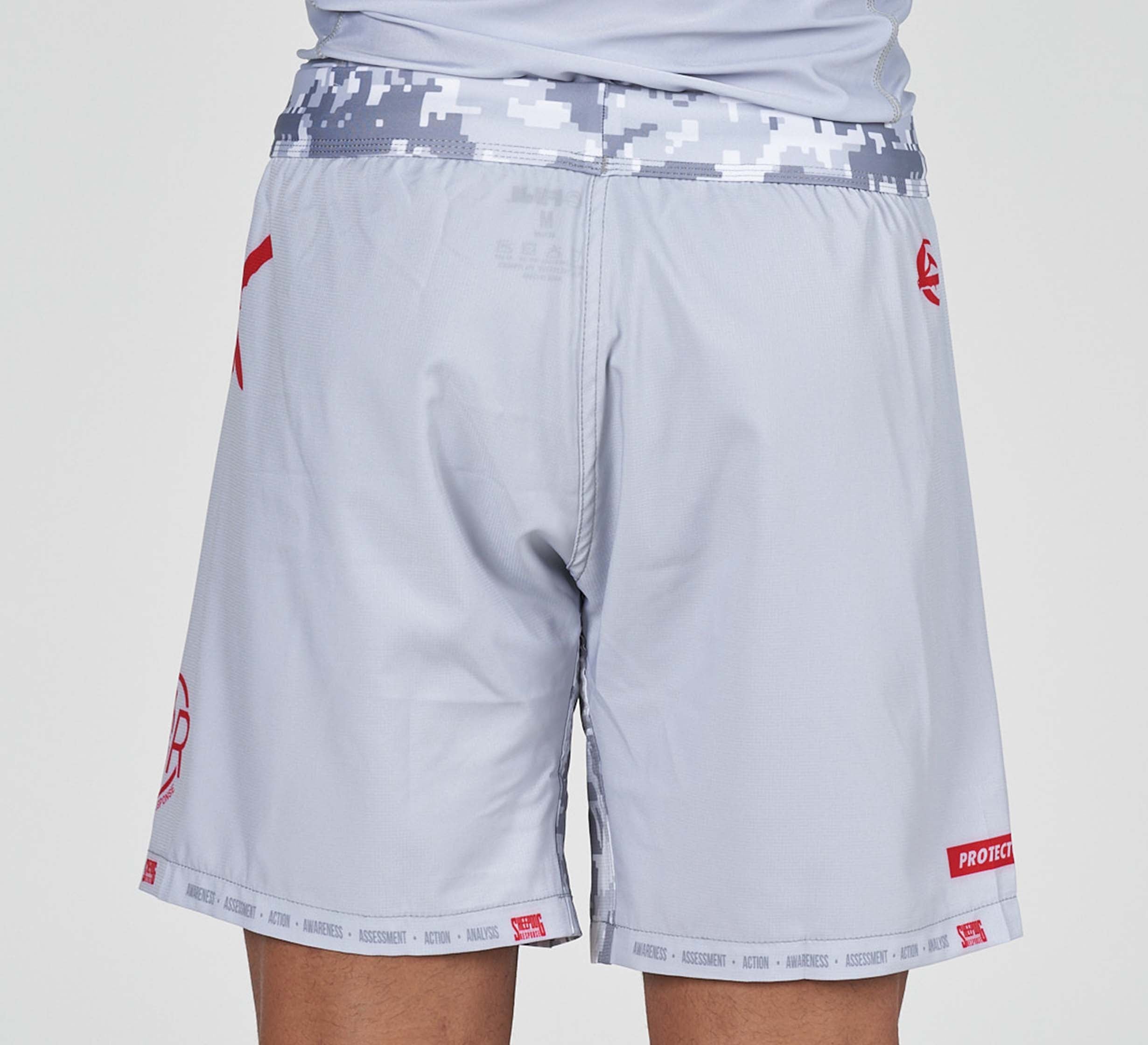 A person wearing Sheepdog Response Flex Lite Shorts Grey with a digital camouflage waistband and red accents is shown from the back against a plain background.