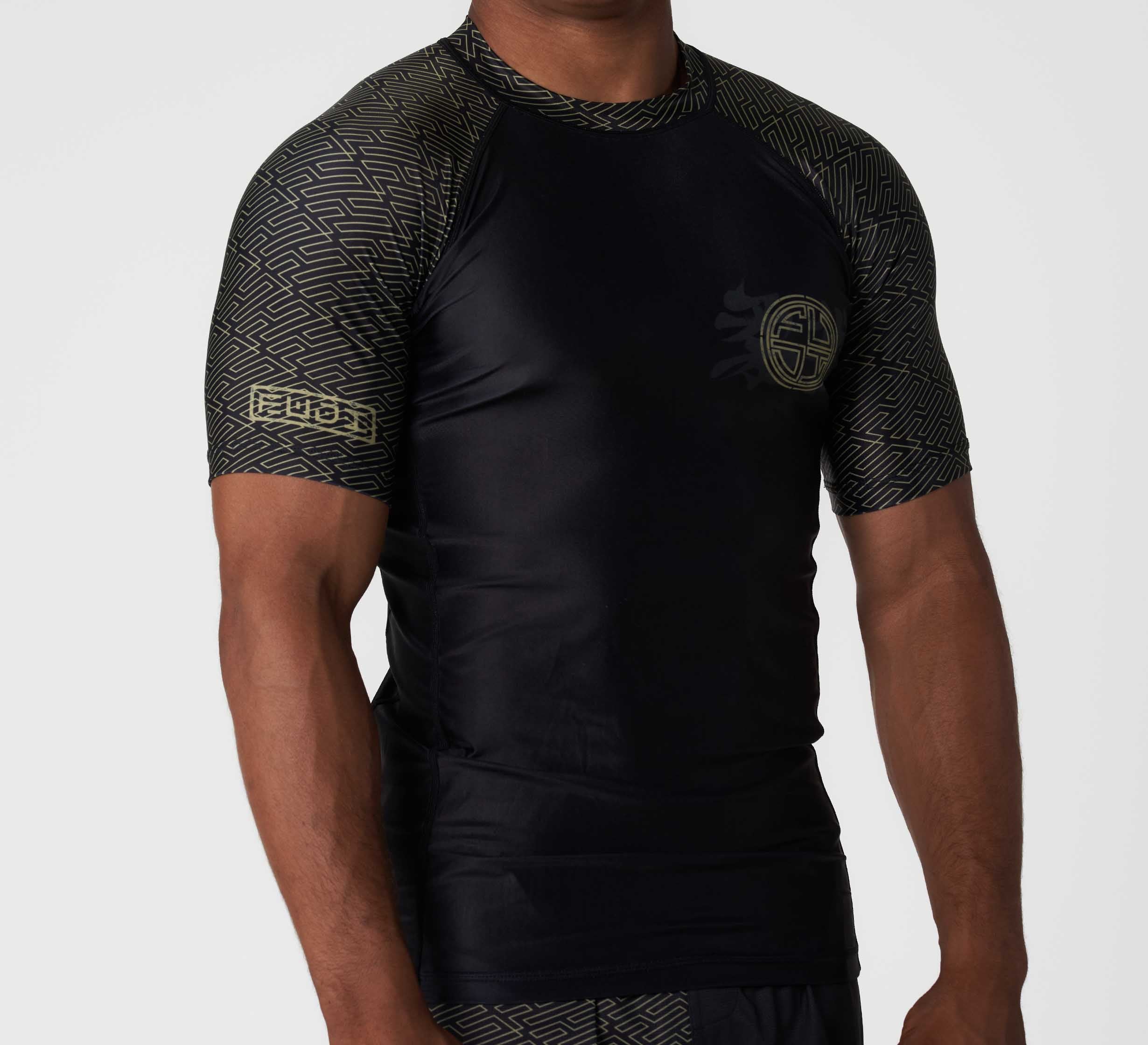 Someone wearing the Bushido Flex Lite Rashguard—a fitted, short-sleeve black athletic shirt featuring geometric sleeve and shoulder patterns, and a subtle circular logo on the chest.