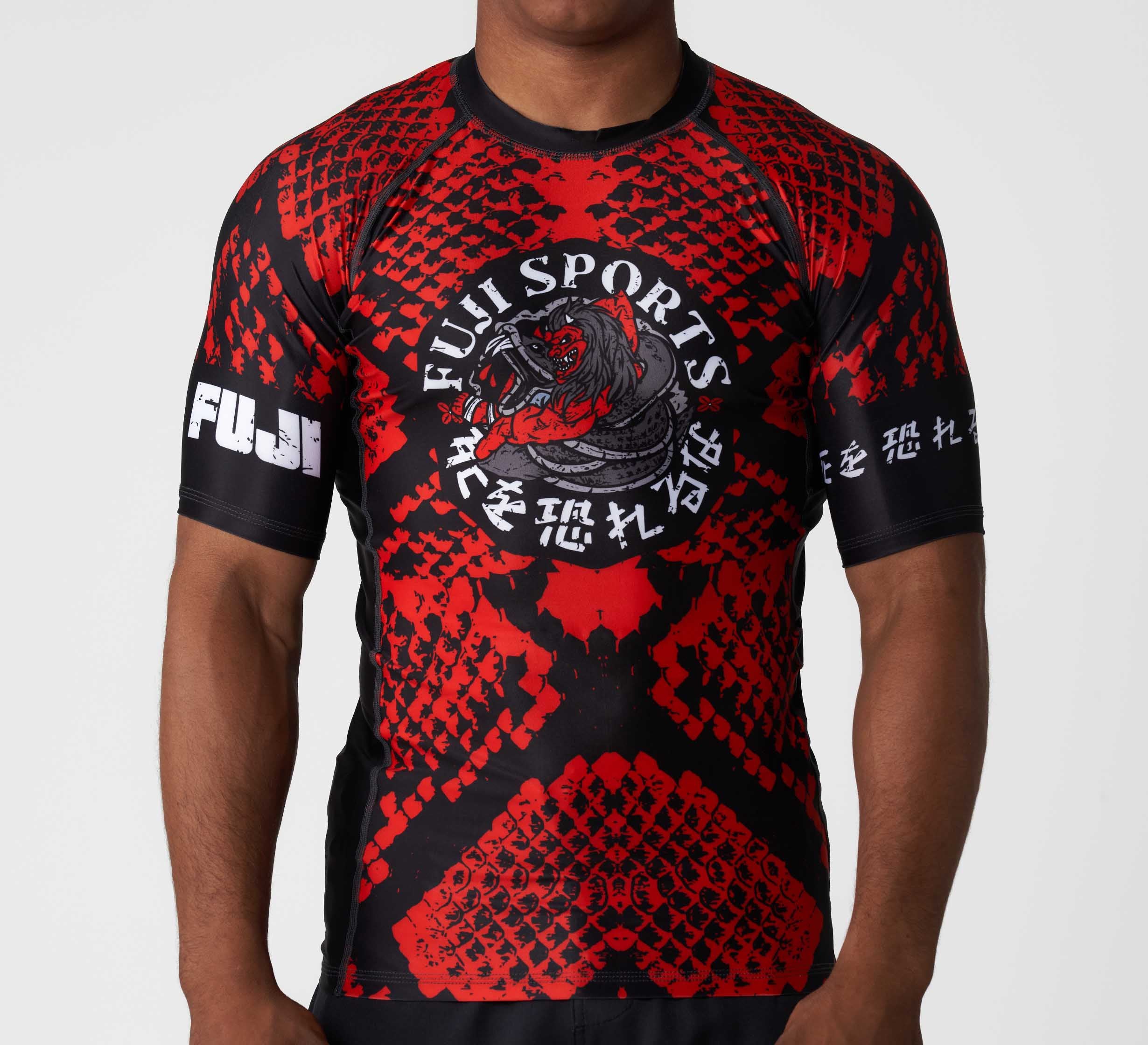 A man wearing the Oni vs. Anaconda Short Sleeve Rashguard in red and black.