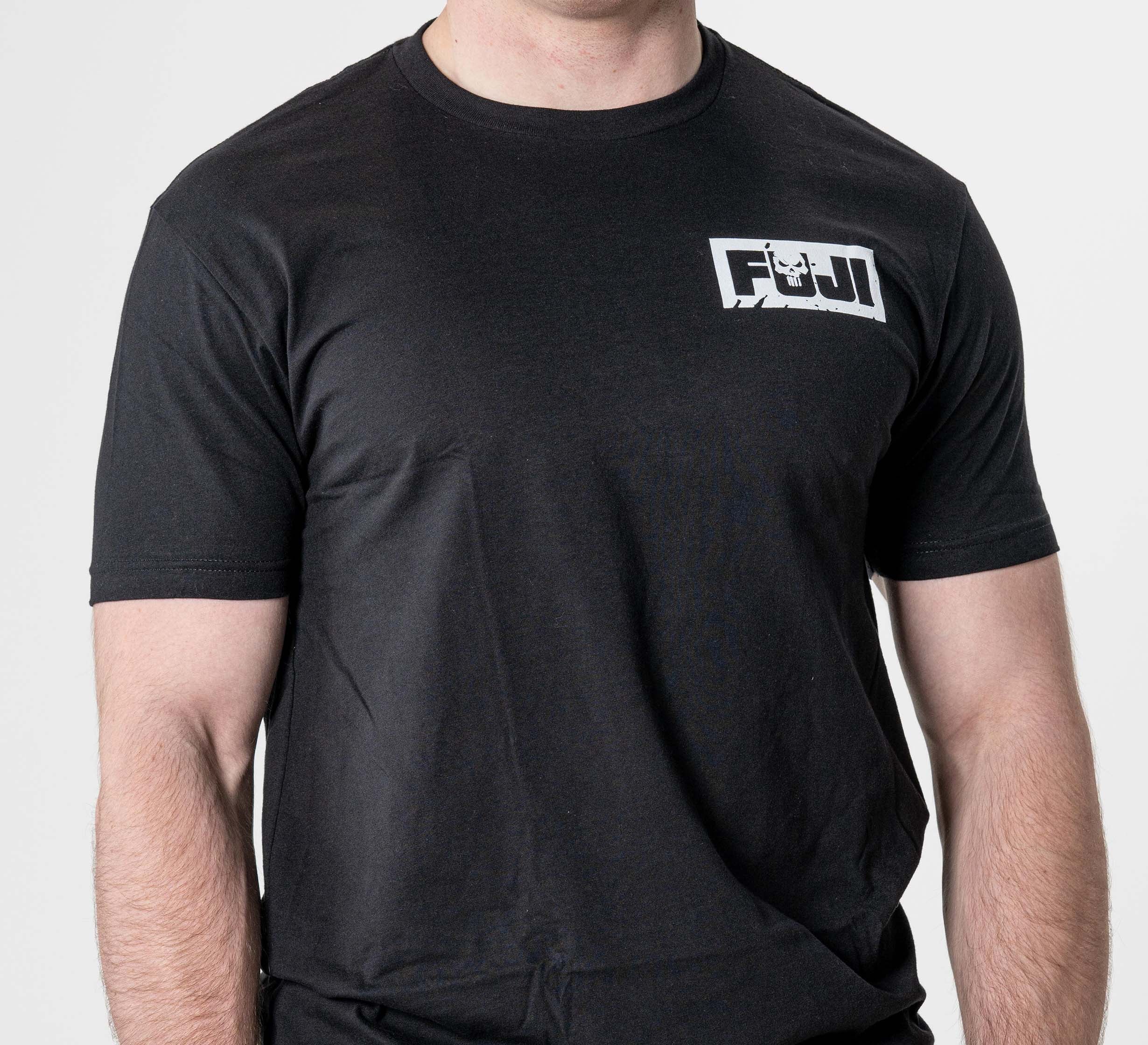A person wears the Punishment T-Shirt Black, featuring a small white “FUJI” logo on the upper left chest. Their head is not visible, and the background is plain white.