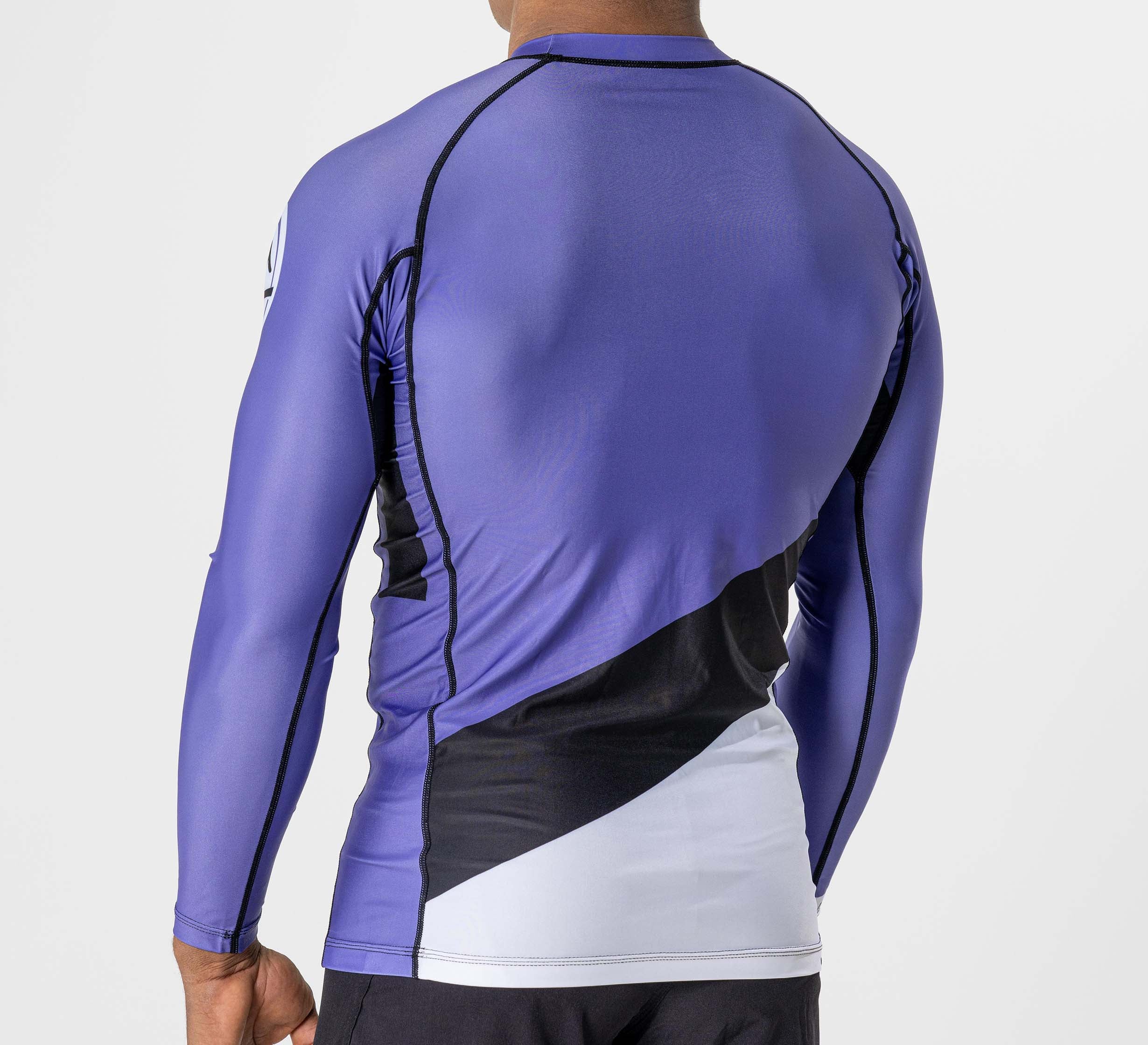 A man shown from the back against a plain light background wears the Pacer Flex Lite Long Sleeve Rashguard in purple.
