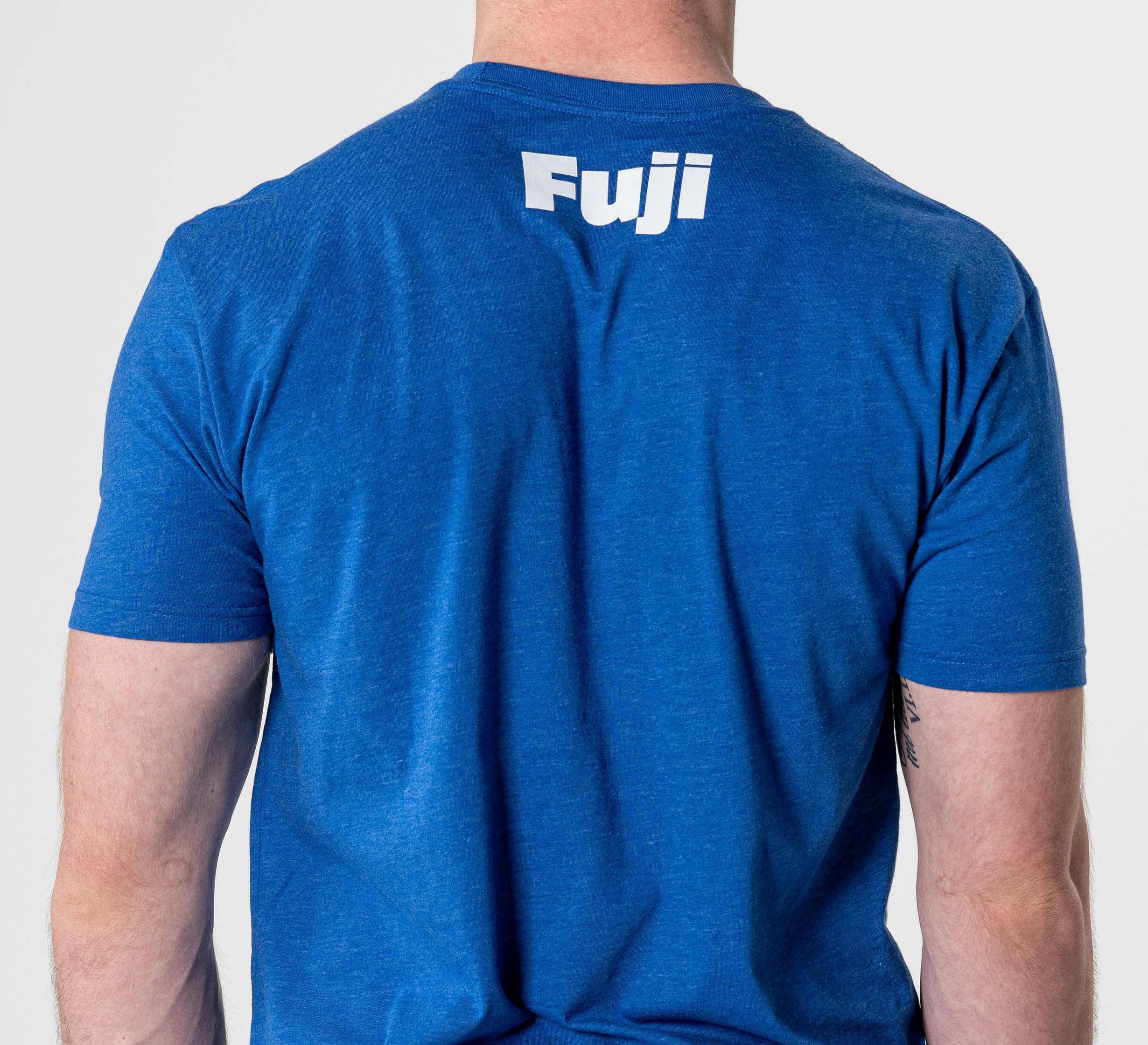 A person is seen from behind wearing the Jiu Jitsu Player T-Shirt Blue, featuring "Fuji" printed in white letters near the top of the back.