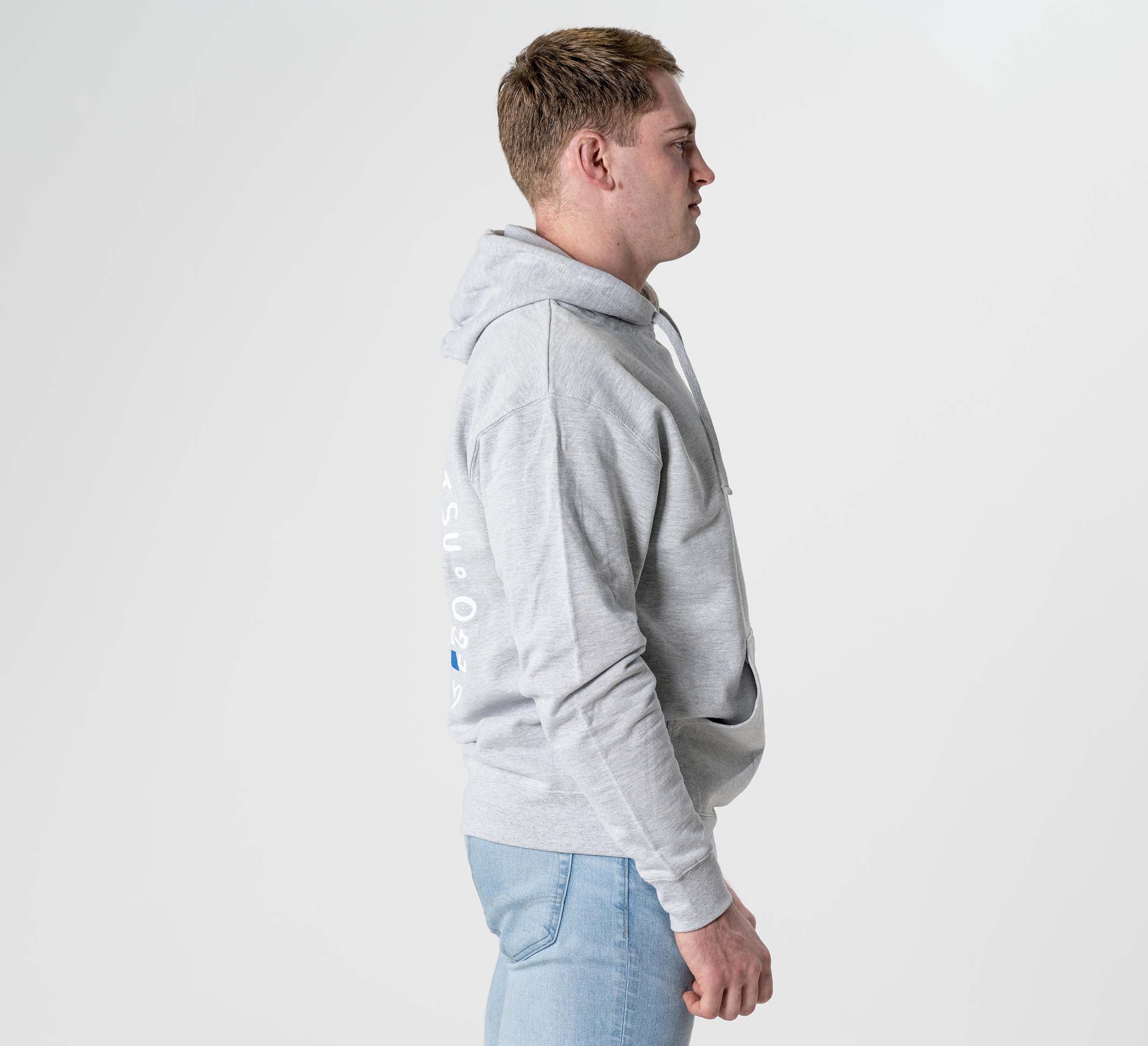 A person wearing the Submit Your Ego Hoodie in Heather Grey and light blue jeans stands in profile against a plain white background.