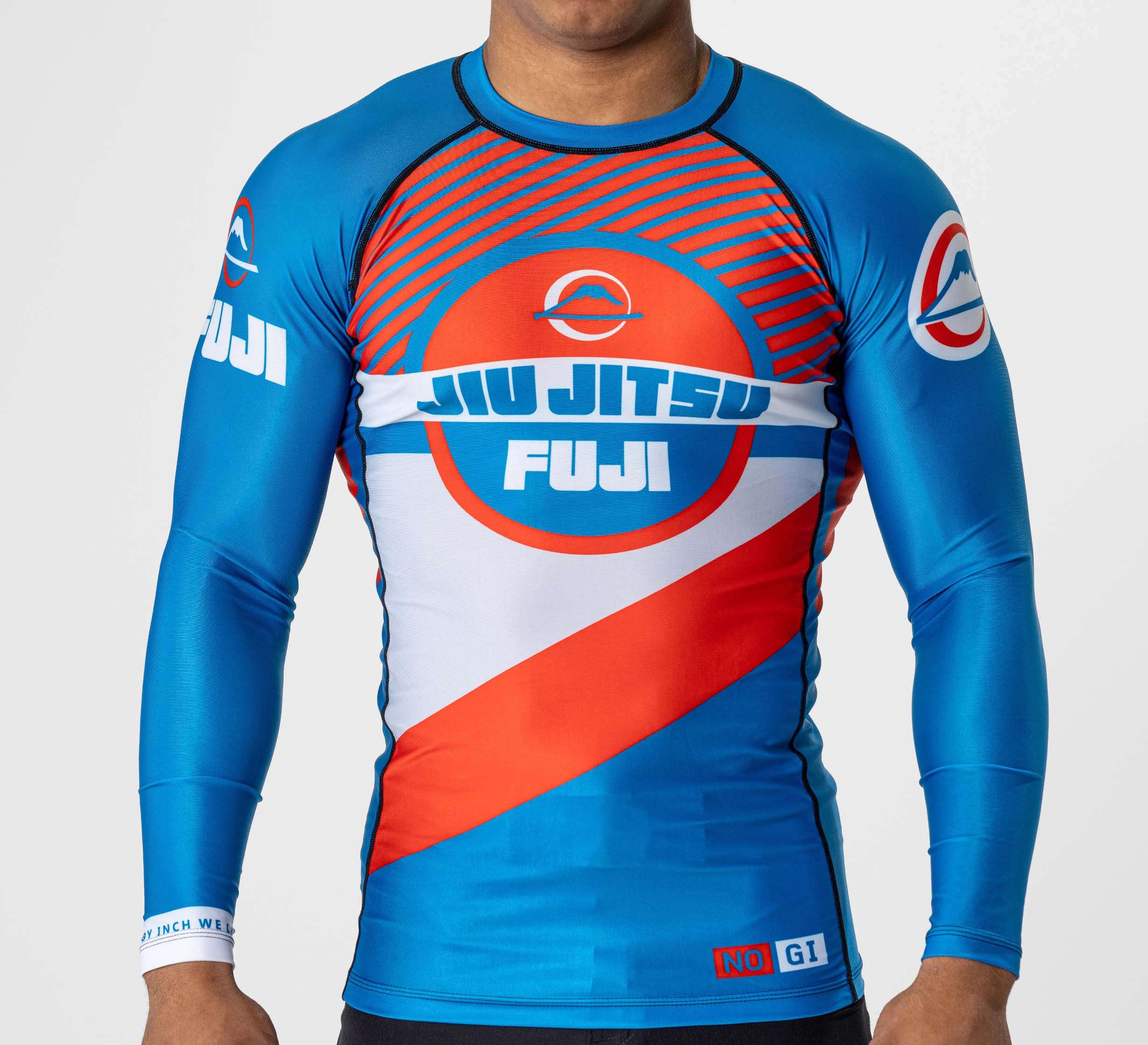 Someone wearing the Pacer Flex Lite Long Sleeve Rashguard Blue/Red, which features bold blue, red, and white stripes, JIU JITSU FUJI text and logos on the chest and sleeves, plus a circular emblem in the design.