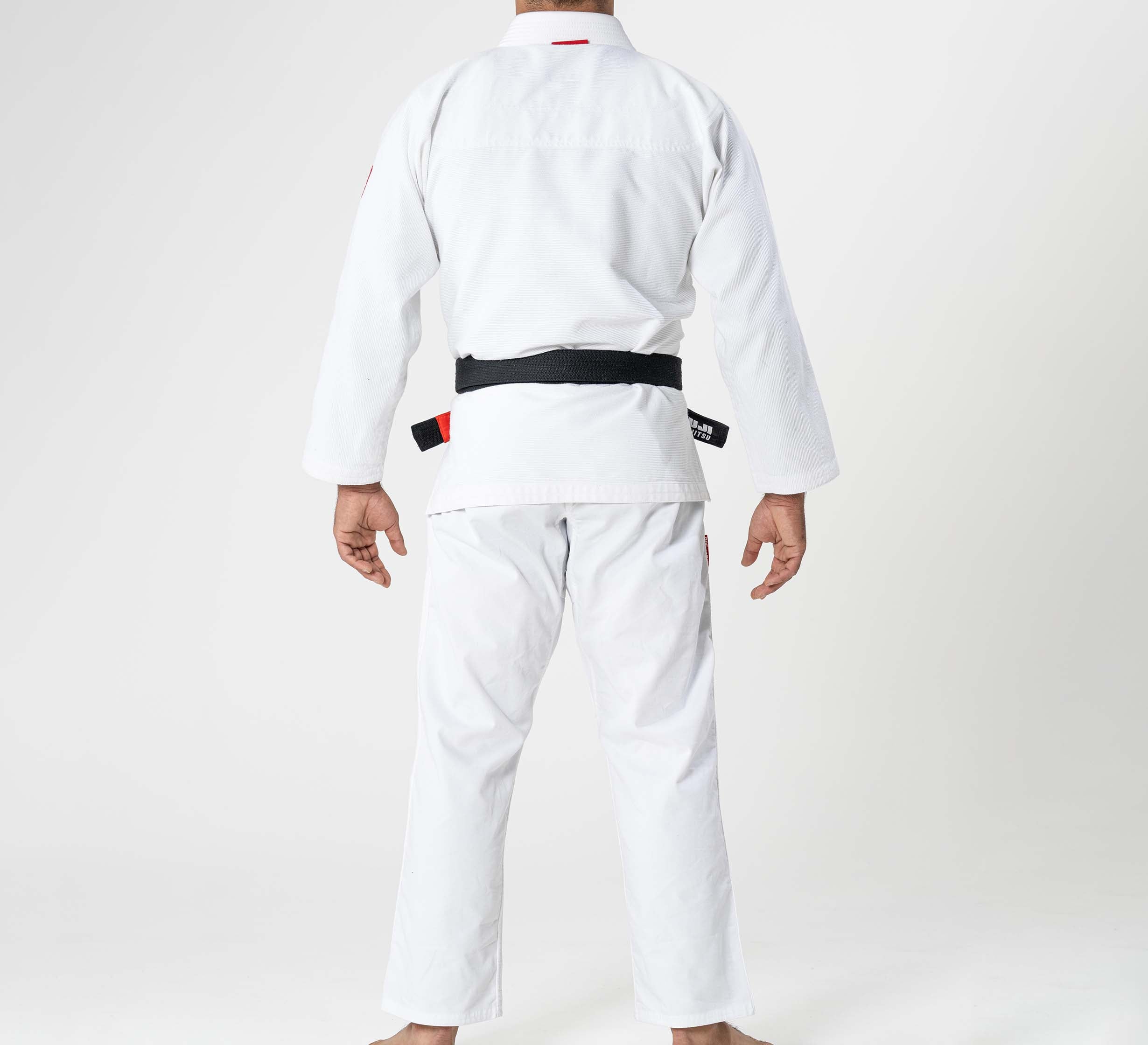 A child wearing the Kids Ultra Lite 300 BJJ Gi White stands barefoot, back turned, against a plain white background.