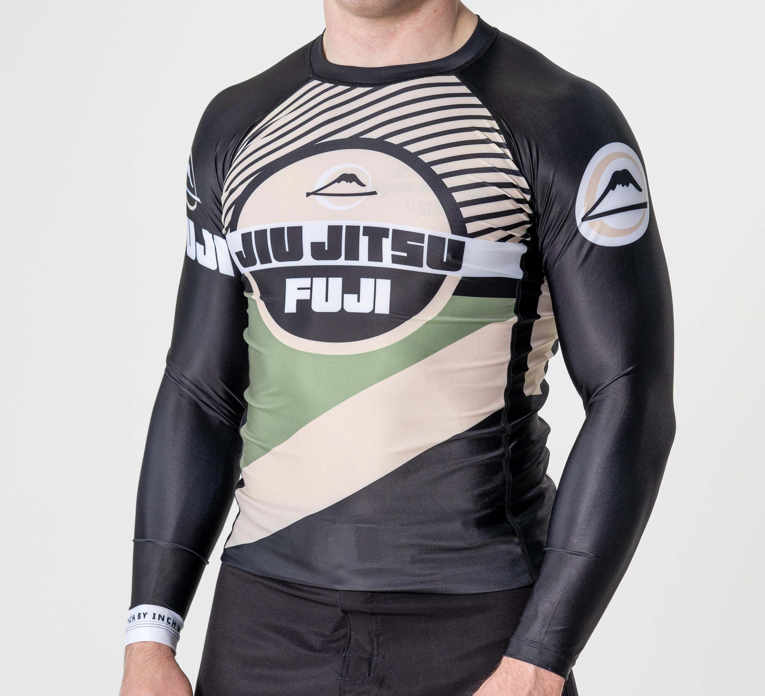 A person wearing the Pacer Flex Lite Long Sleeve Rashguard Black, featuring Jiu Jitsu and Fuji text with mountain logos on the chest and sleeves, stands against a plain white background.