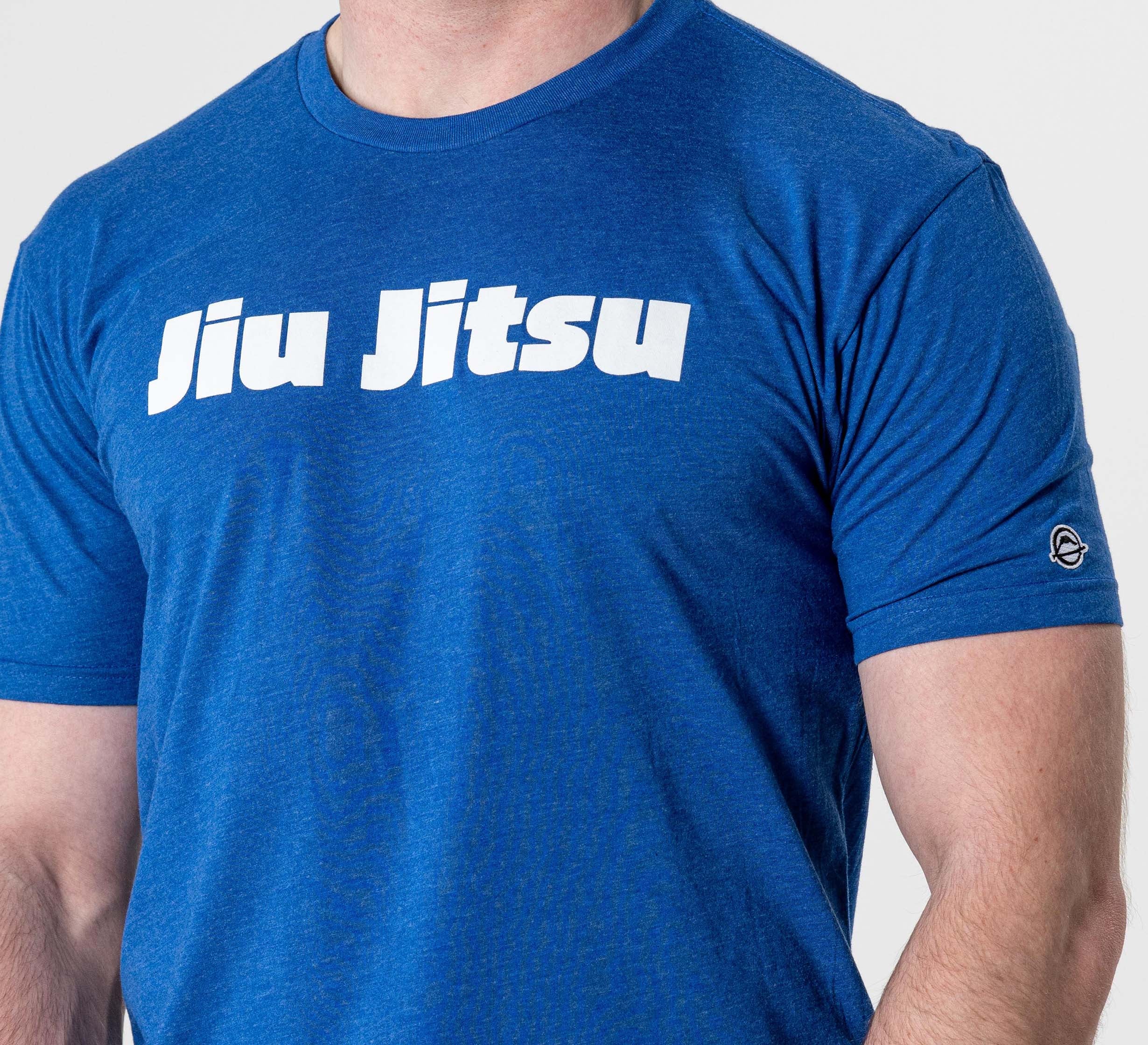 A person is shown from the waist up wearing the Jiu Jitsu Player T-Shirt Blue with "Jiu Jitsu" boldly printed in white across the chest.