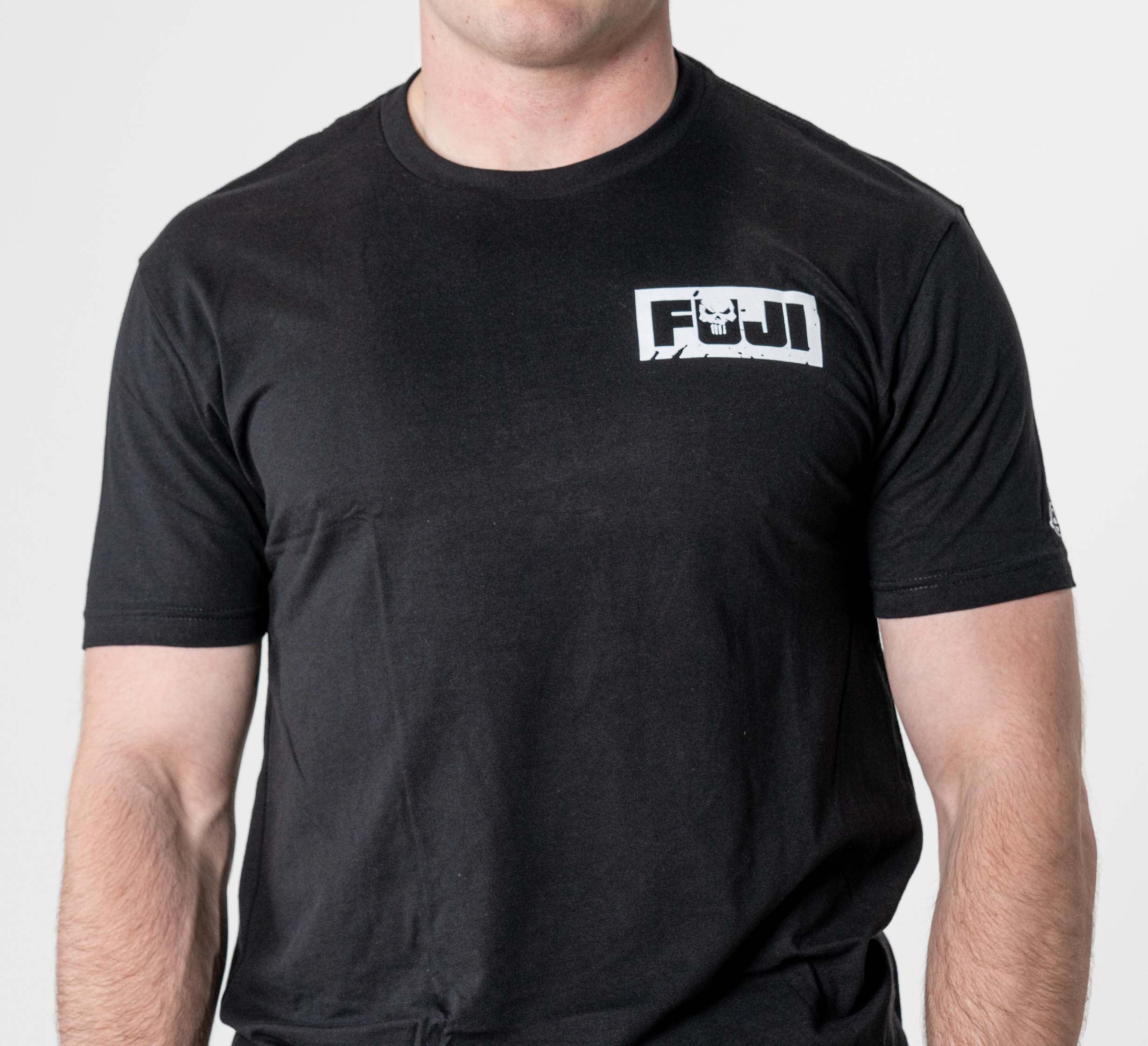 A person wearing the Punishment T-Shirt Black, featuring a small white FUJI logo on the left chest, stands against a white background with their face not visible.