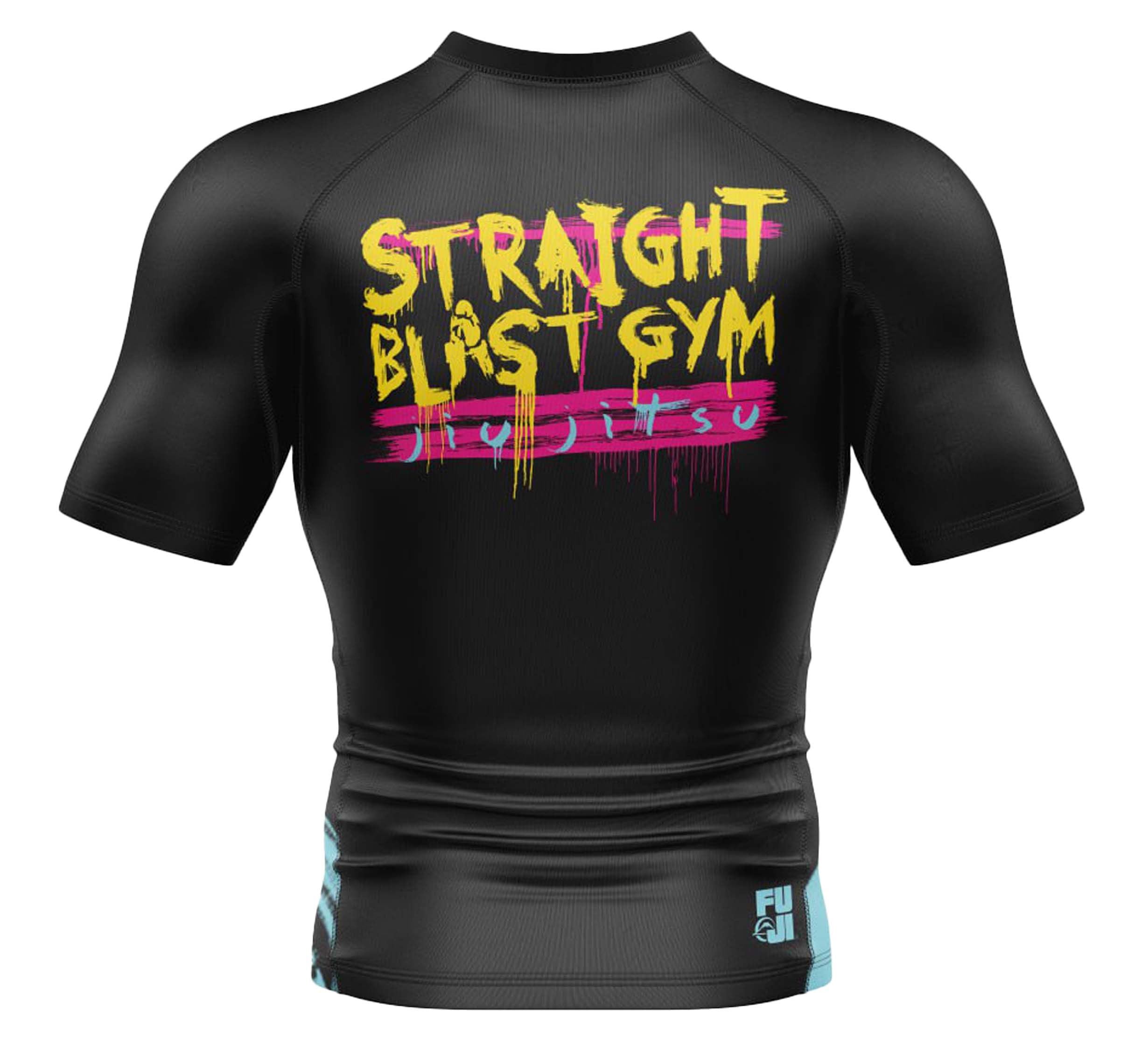 The SBG Grunge Gorilla Youth Short Sleeve Rashguard is black with colorful graffiti-style “STRAIGHT BLAST GYM JIU JITSU” text on the back and a small white and blue FUJI Sports logo on the lower left.