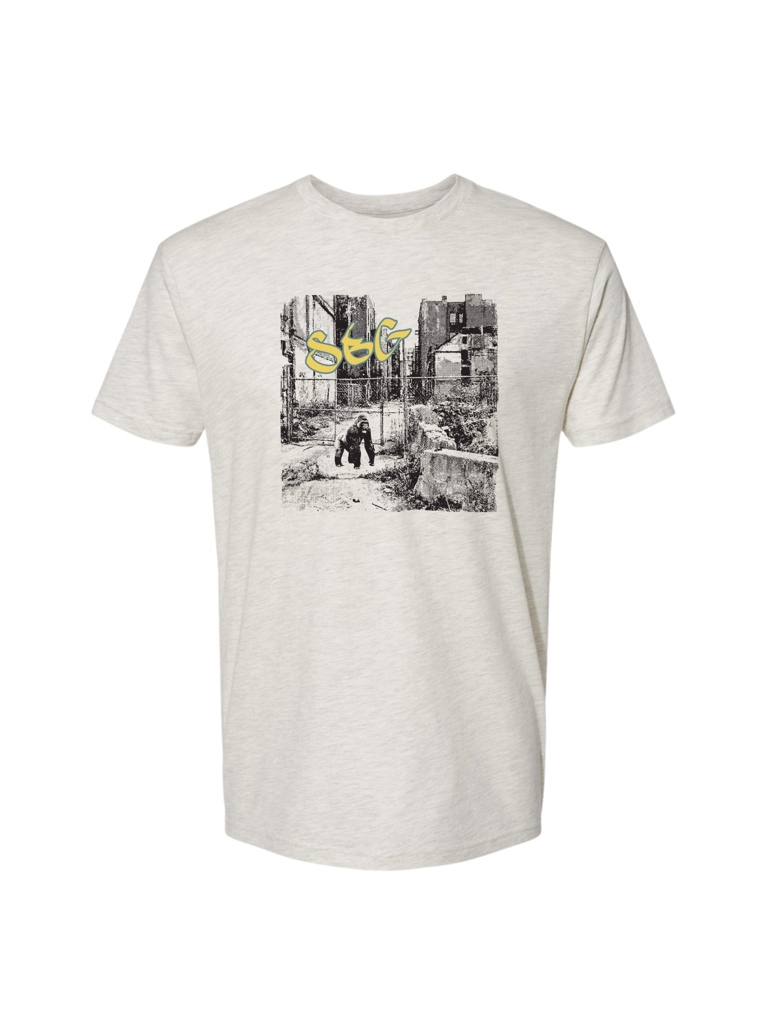 The SBG Junkyard T-Shirt Oatmeal is a light gray tee with a black-and-white urban scene graphic of two people walking, highlighted by bold yellow "SEG" lettering.