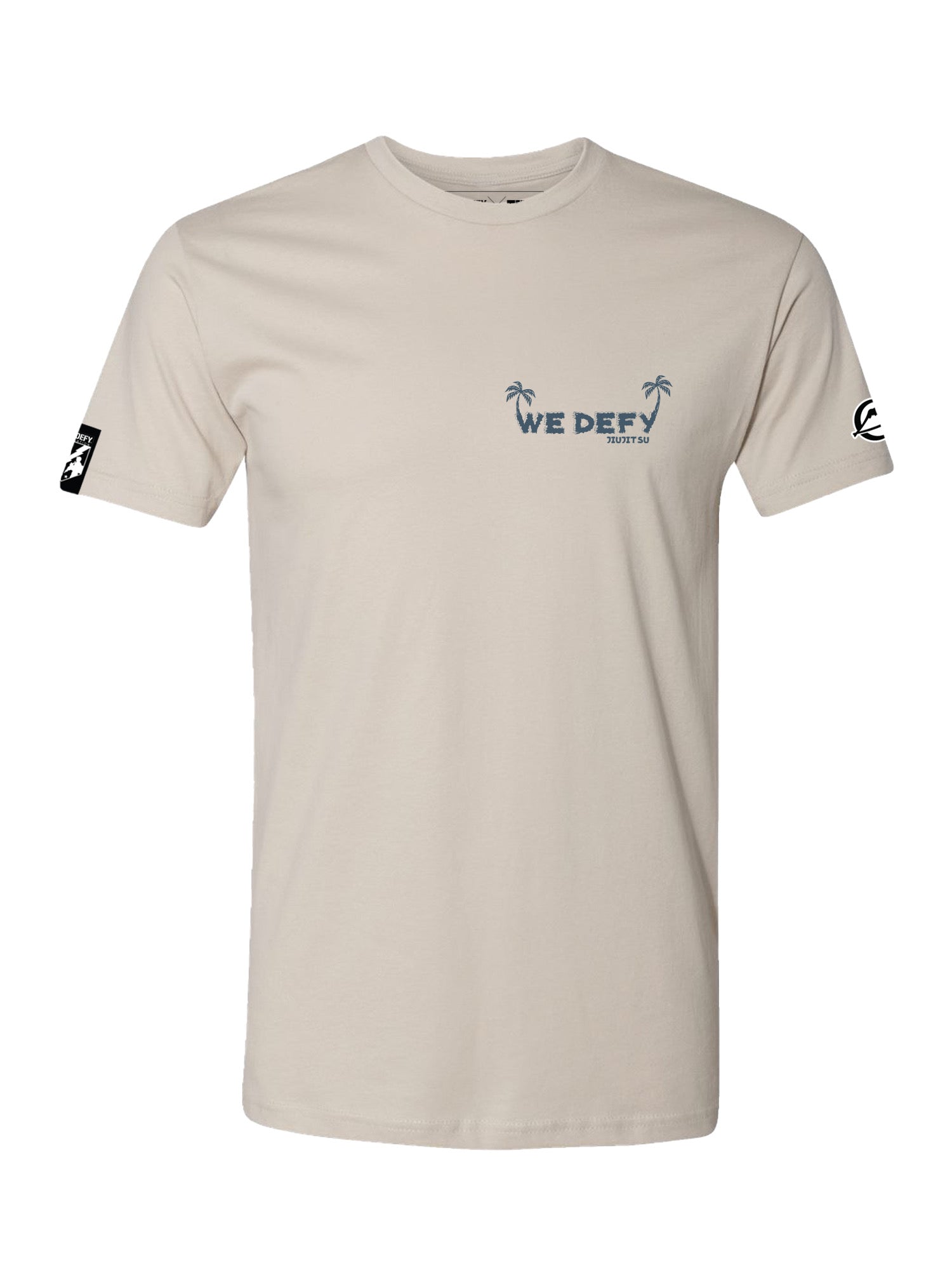 The We Defy Beach Vibes T-Shirt Sand features light beige fabric, a classic crew neck, small blue “WE DEFY” text with two palm trees on the left chest, plus black and white graphics on both sleeves.