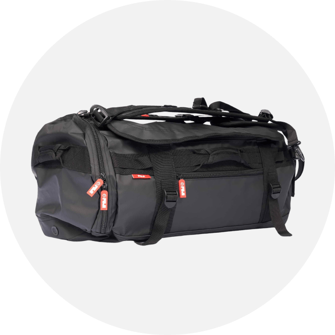 A black duffel bag with multiple straps, zippers, and red zipper pulls, displayed on a light grey circular background.