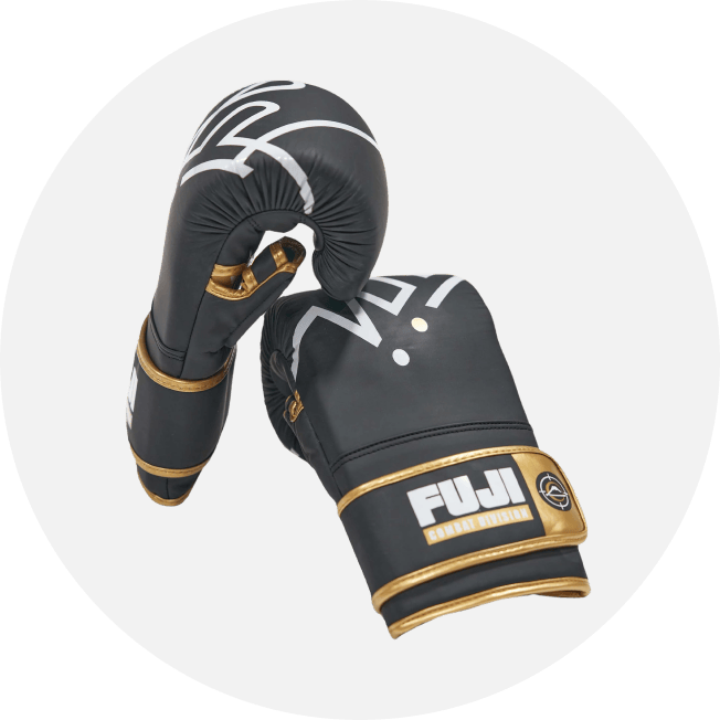 A pair of black and gold boxing gloves with FUJI and SPORTS EQUIPMENT printed on the wrist area, displayed against a light gray background.