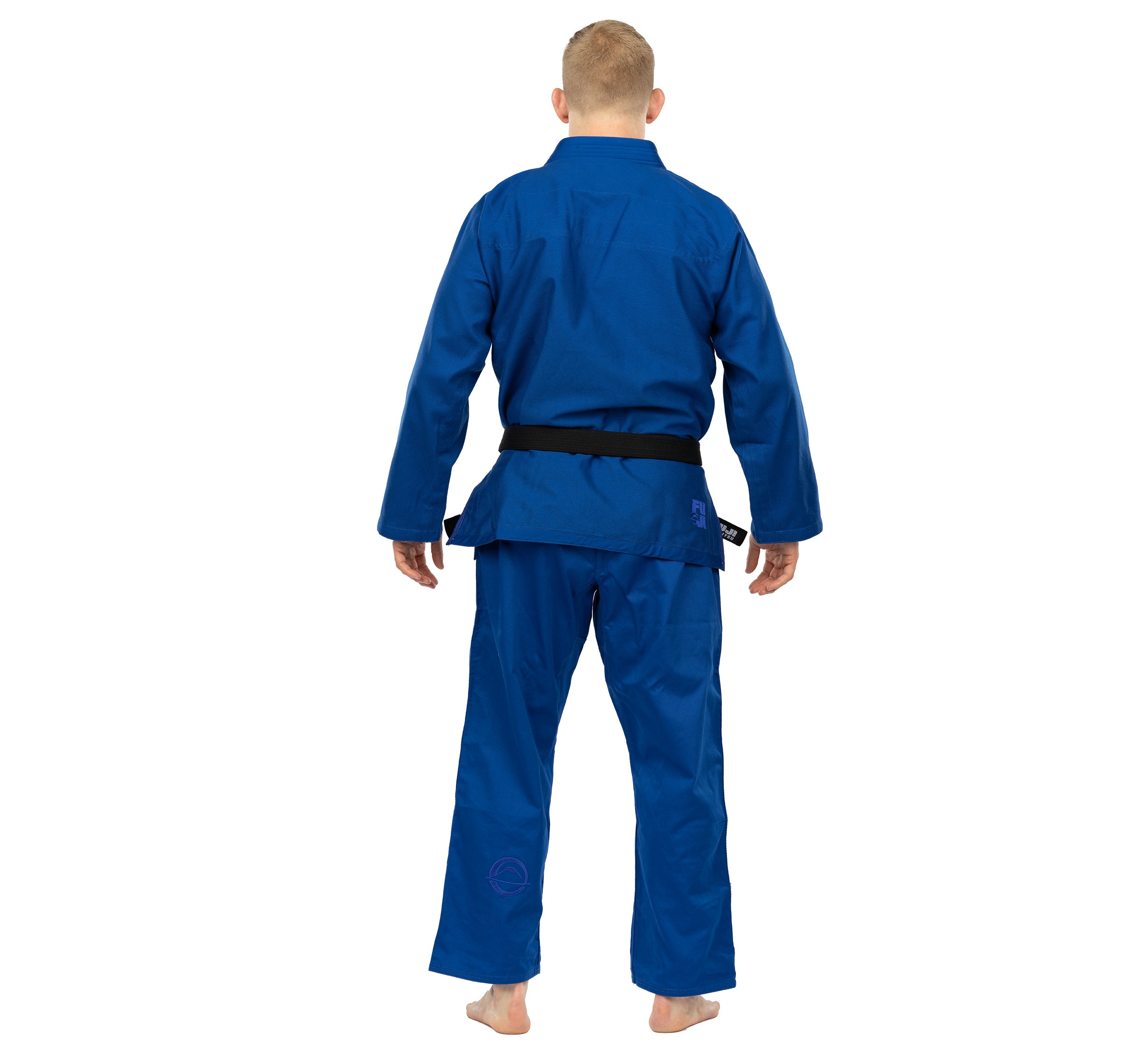 A person stands barefoot facing away from the camera, showcasing the back of their Elemental BJJ Gi Blue and a black belt.