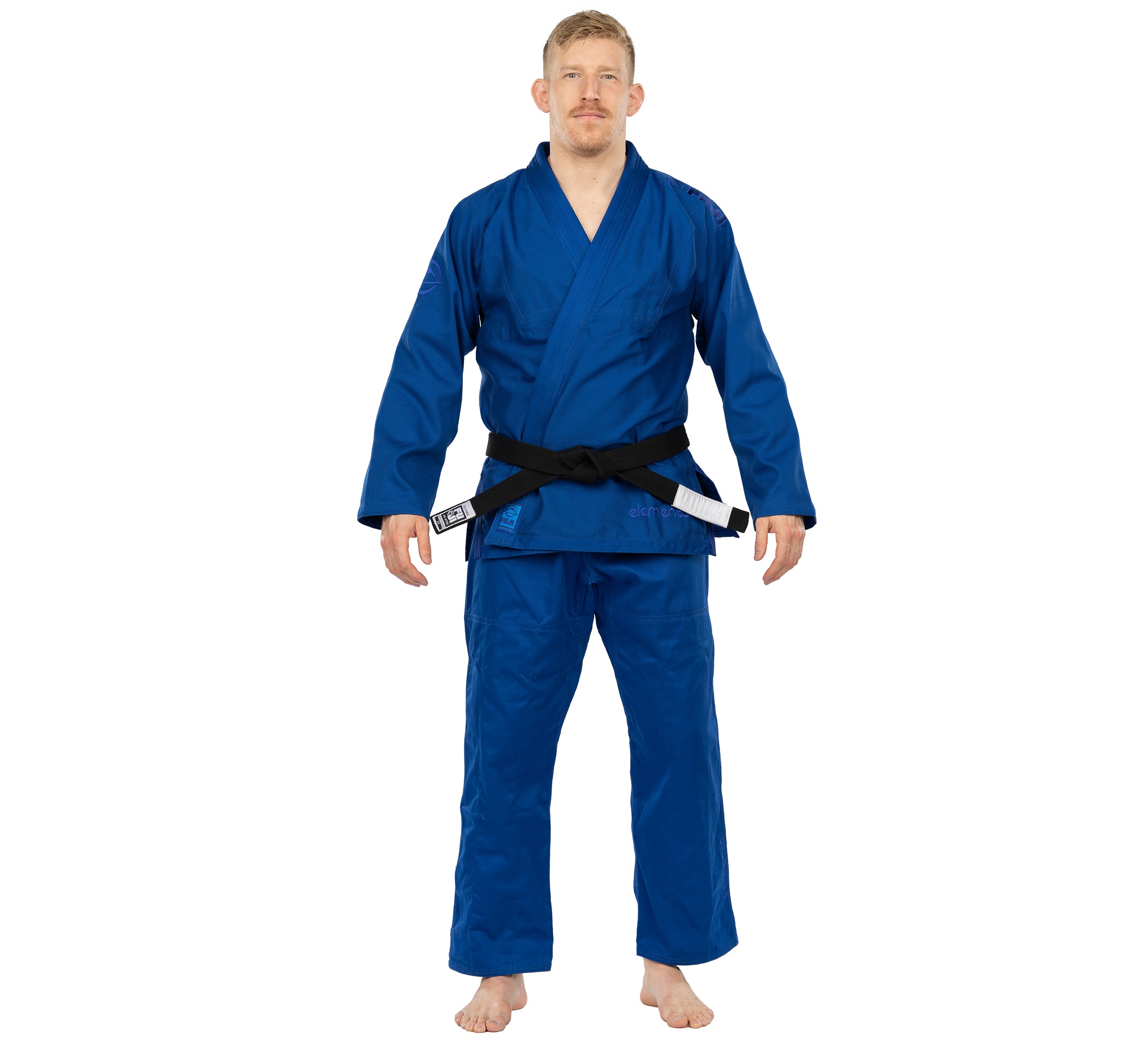 A person stands barefoot, facing forward with arms relaxed by their sides, wearing the Elemental BJJ Gi Blue and a black belt against a plain white background.