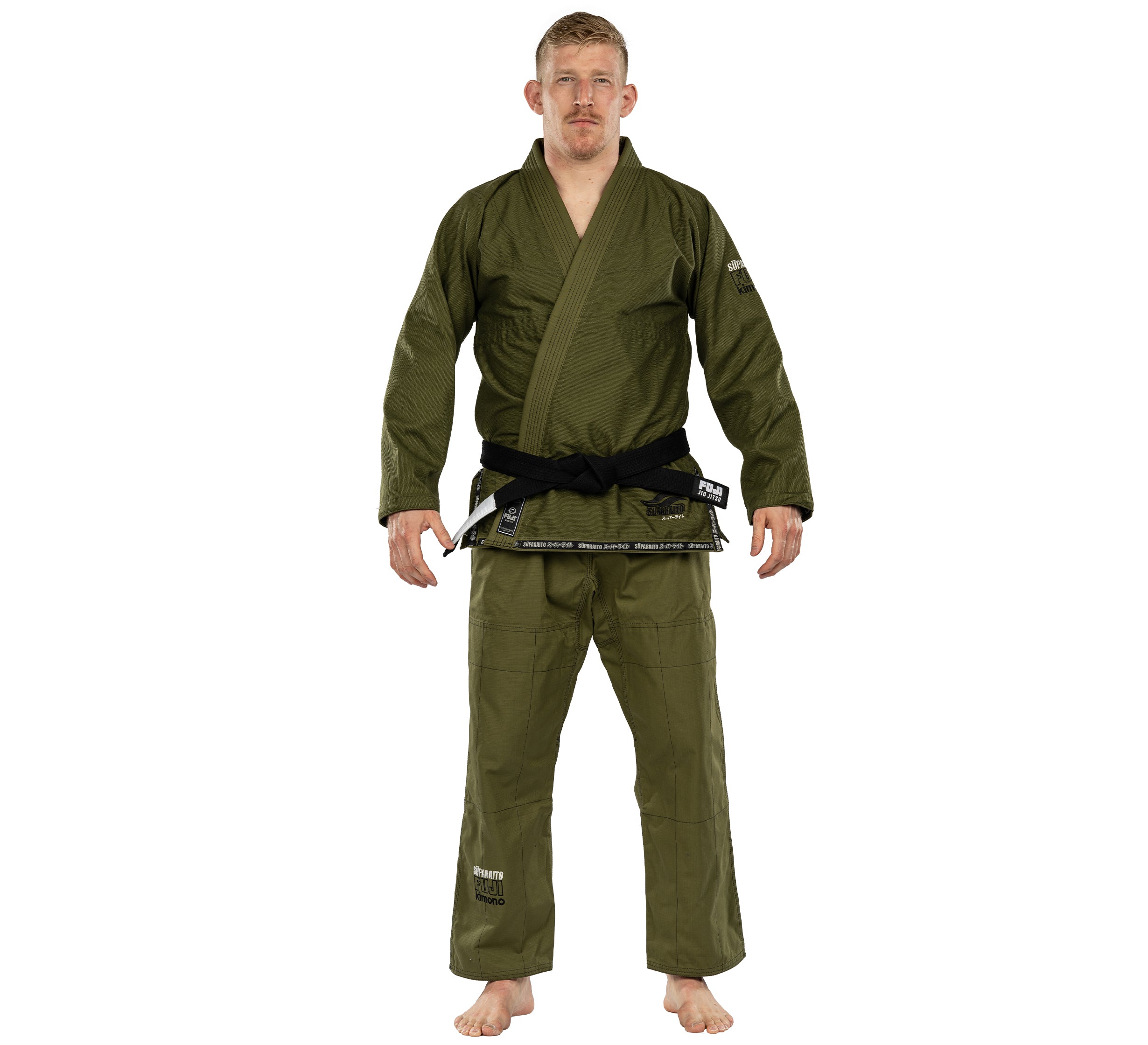 A man in a Suparaito BJJ Gi, olive green with a black belt, stands barefoot on a white background facing forward, arms slightly out to his sides.