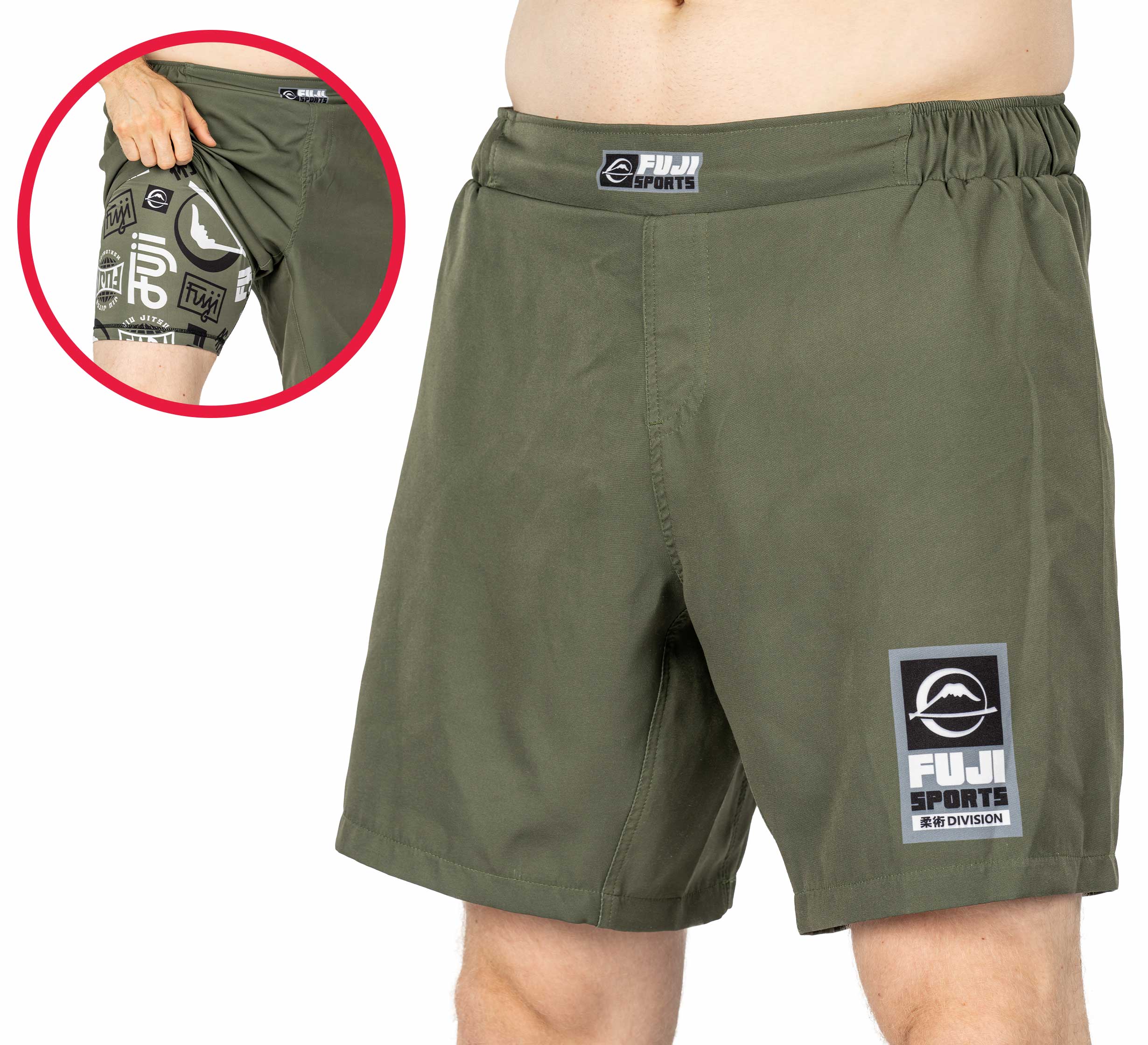 The Ultimate Grappling Shorts in Military Green feature the FUJI Sports logo on the left leg. An inset displays a hidden pocket holding a hand and extra printed logos. The model is shown wearing these athletic shorts.