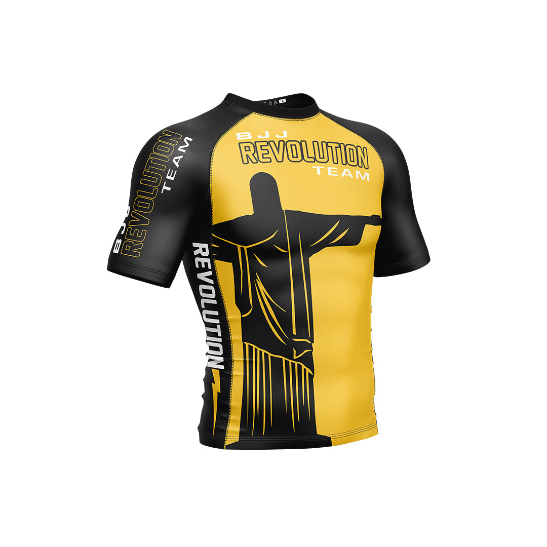 The BJJ Revolution KIDS Ranked Rashguard Short Sleeve in yellow features the Christ the Redeemer statue graphic and REVOLUTION TEAM text on the chest, sleeve, and side.