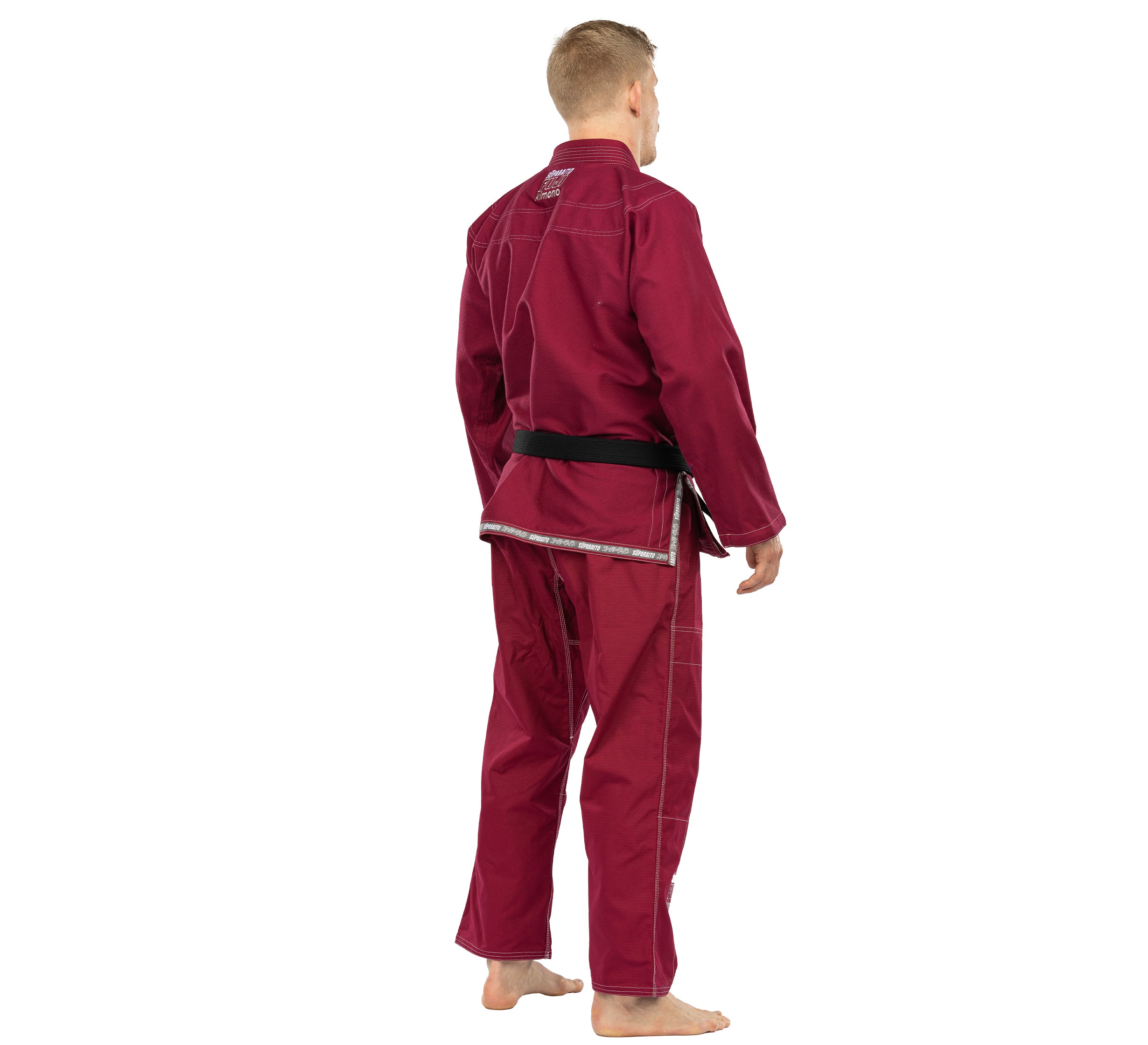 A person faces away from the camera, barefoot, wearing the Suparaito BJJ Gi in burgundy with a black belt, set against a white background.