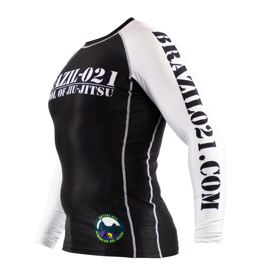The BRAZIL 021 Ranked Rashguard is a black and white long-sleeve rash guard featuring BRAZIL-021 SCHOOL OF JIU-JITSU on the chest, BRAZIL021.COM on the sleeve, and a circular logo near the hem.