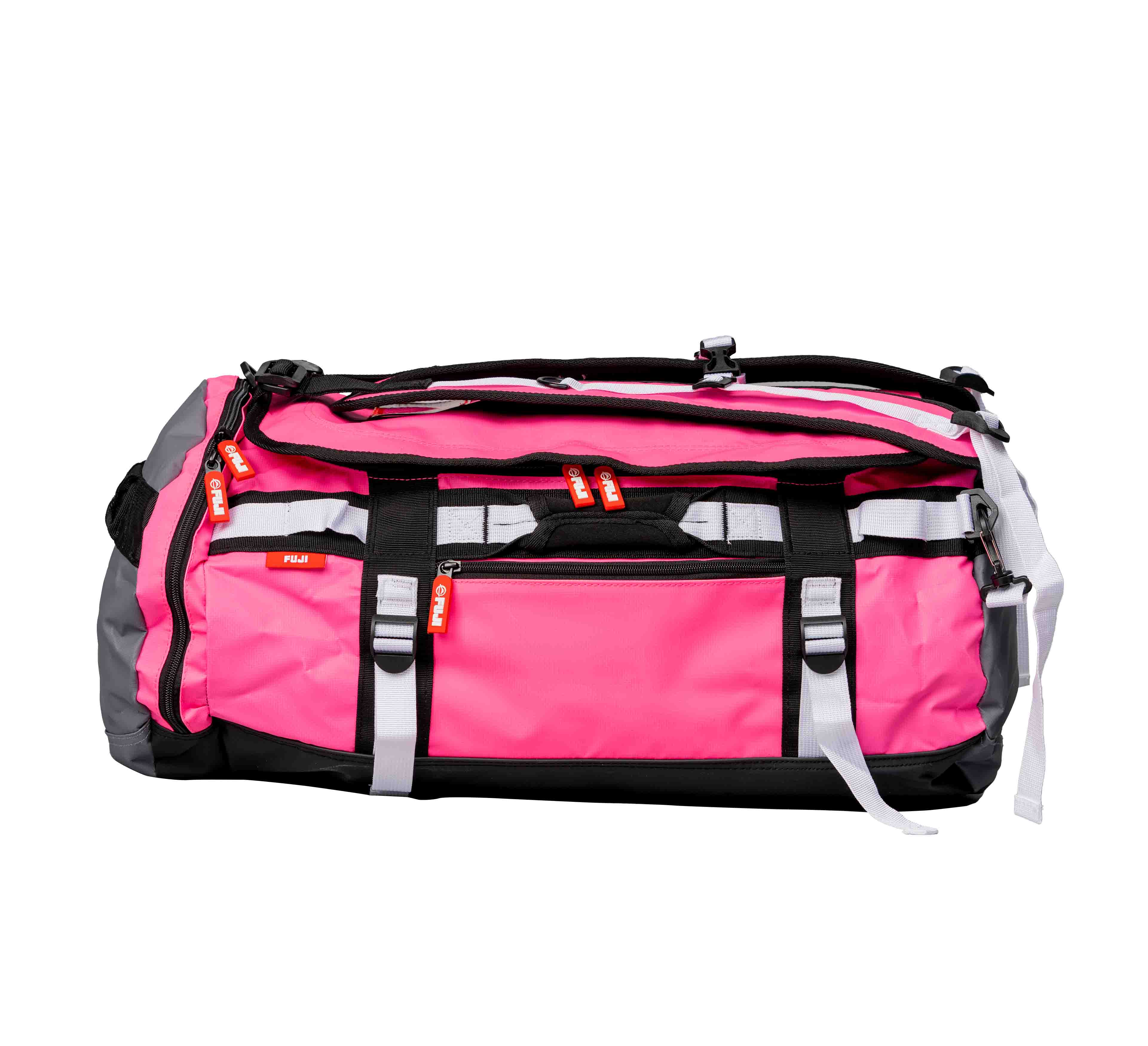 The Comp Convertible Backpack Duffle is a large pink and gray duffel bag featuring black straps, white buckles, and several red zipper pulls, displayed on a plain white background.