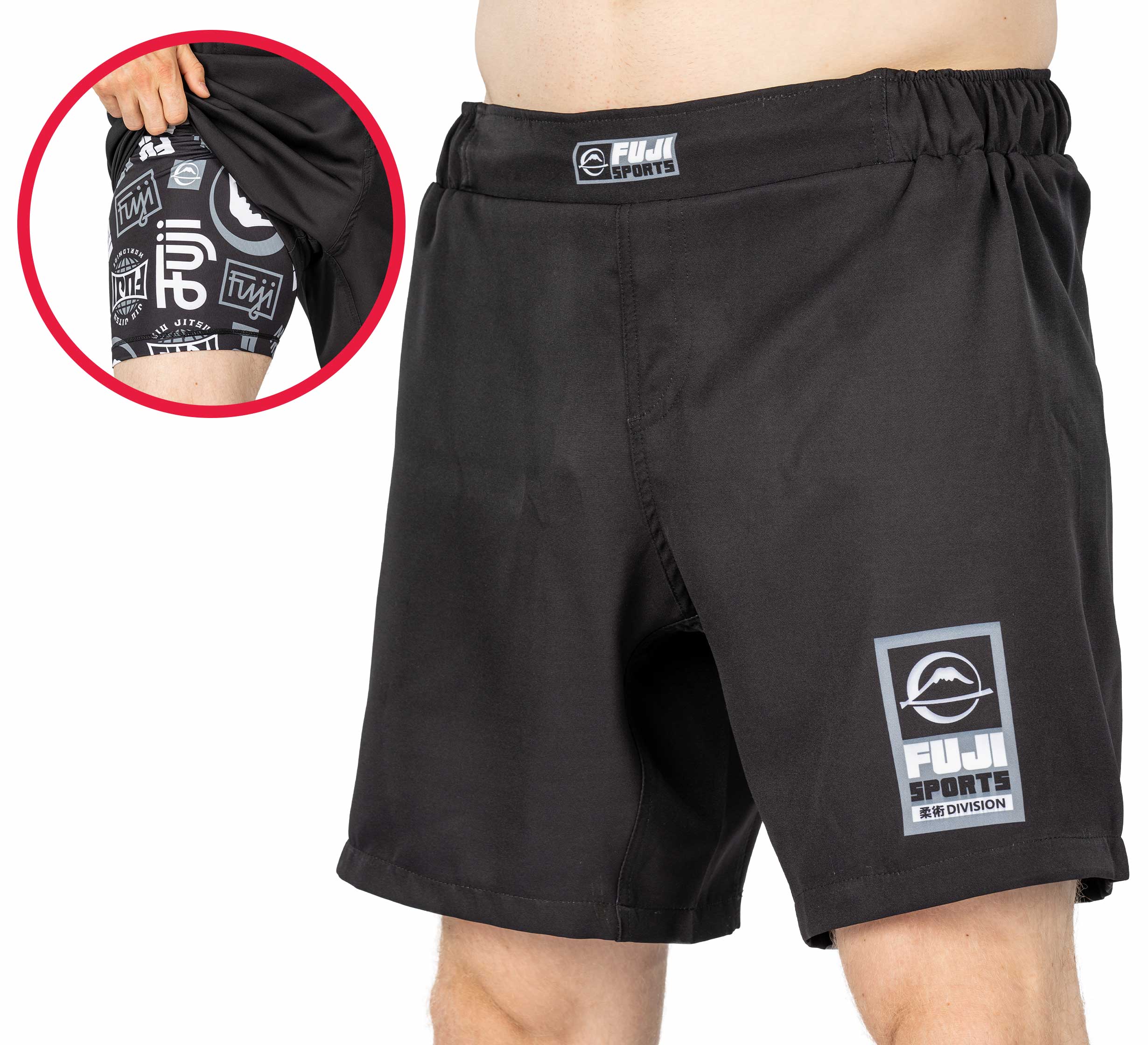 A person wears Ultimate Grappling Shorts Black with a FUJI logo patch on the left leg. An inset displays the inner compression layer featuring black and white FUJI branding and patterns.