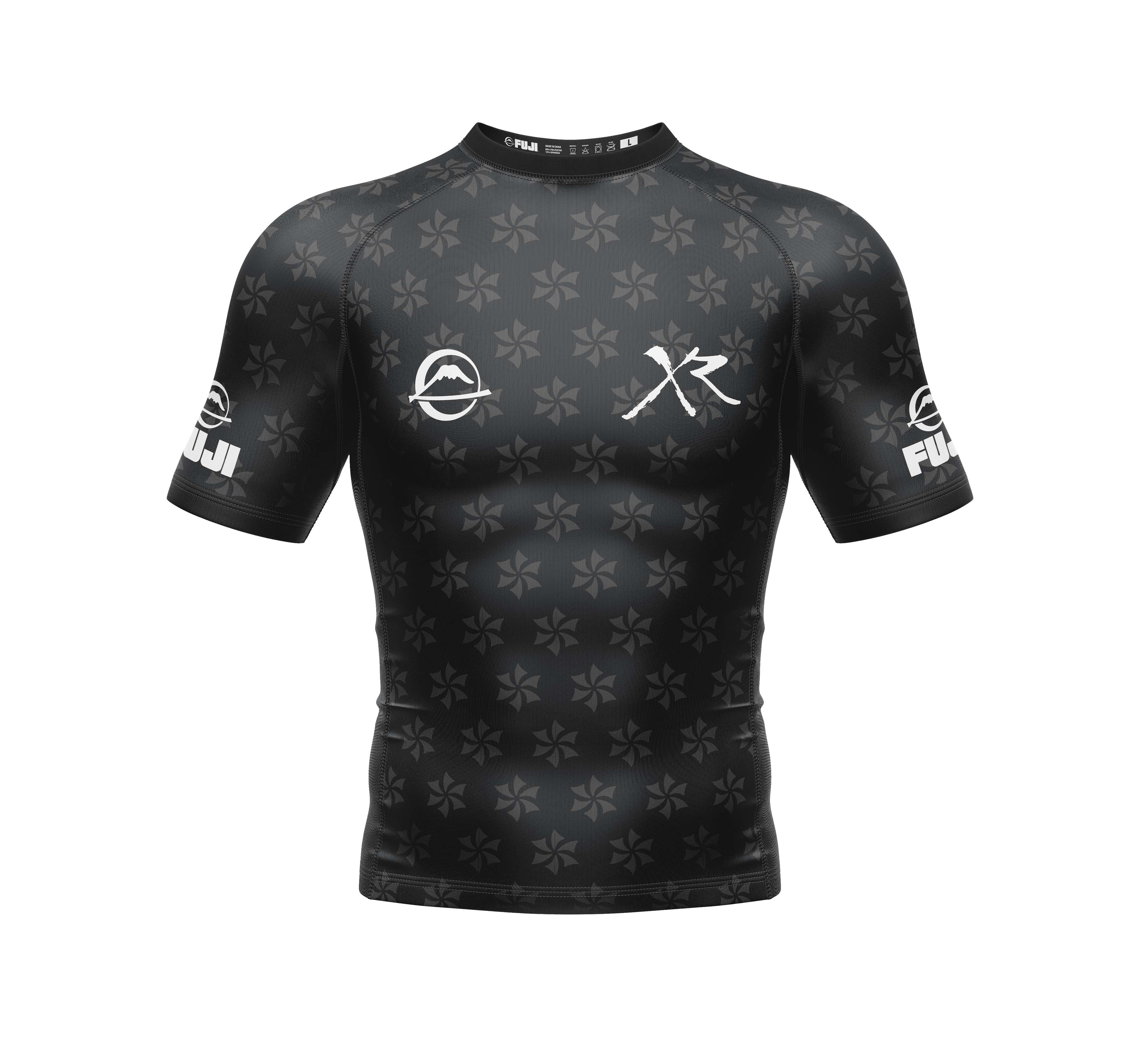 The Xande Comp Short Sleeve Rashguard Black features subtle star patterns, white logos on the chest, sleeves, and collar, and is displayed against a white background.
