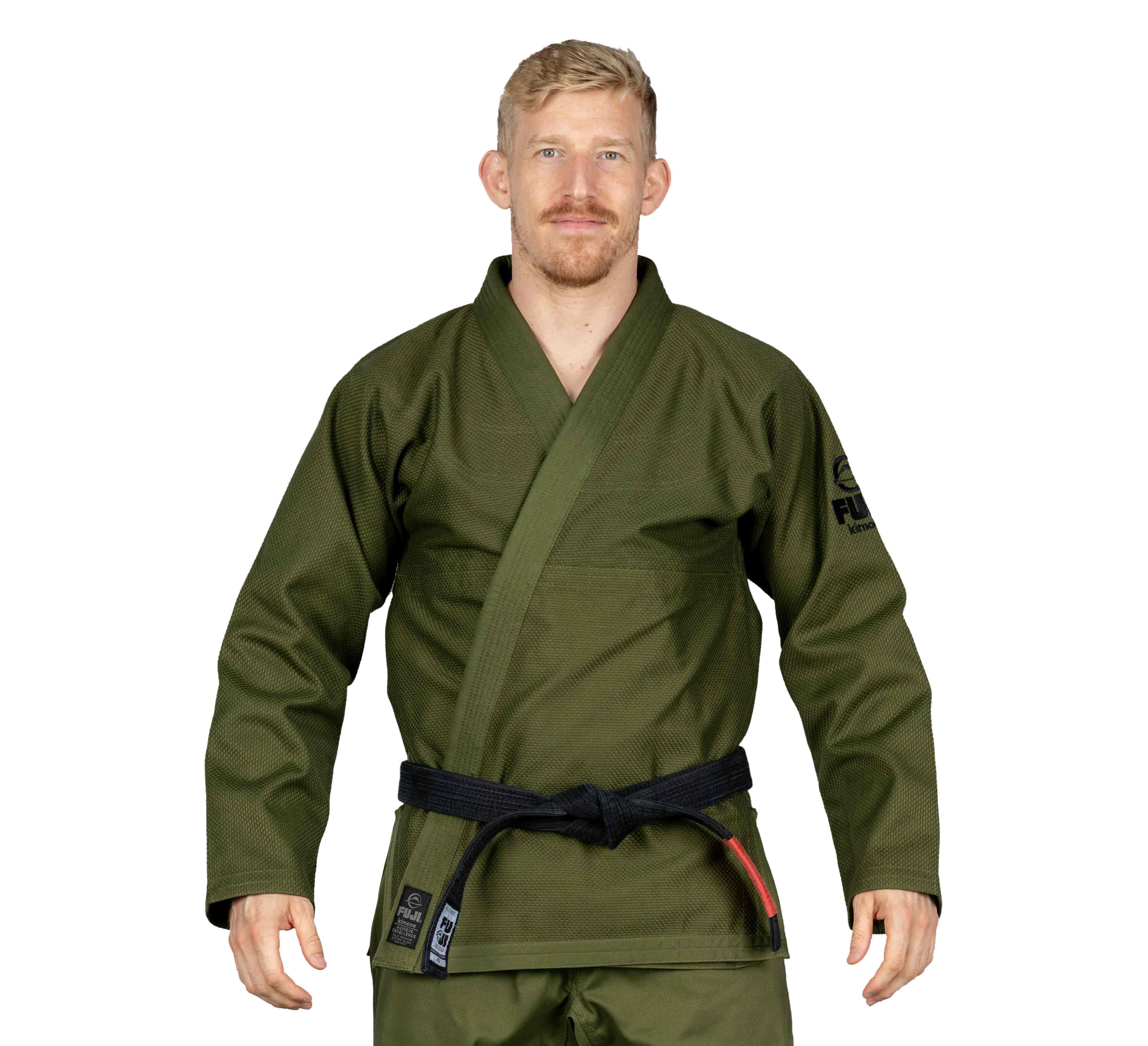 A person with short blond hair and a mustache, wearing the All Around BJJ Gi Military Green and a black belt, stands facing forward against a white background.